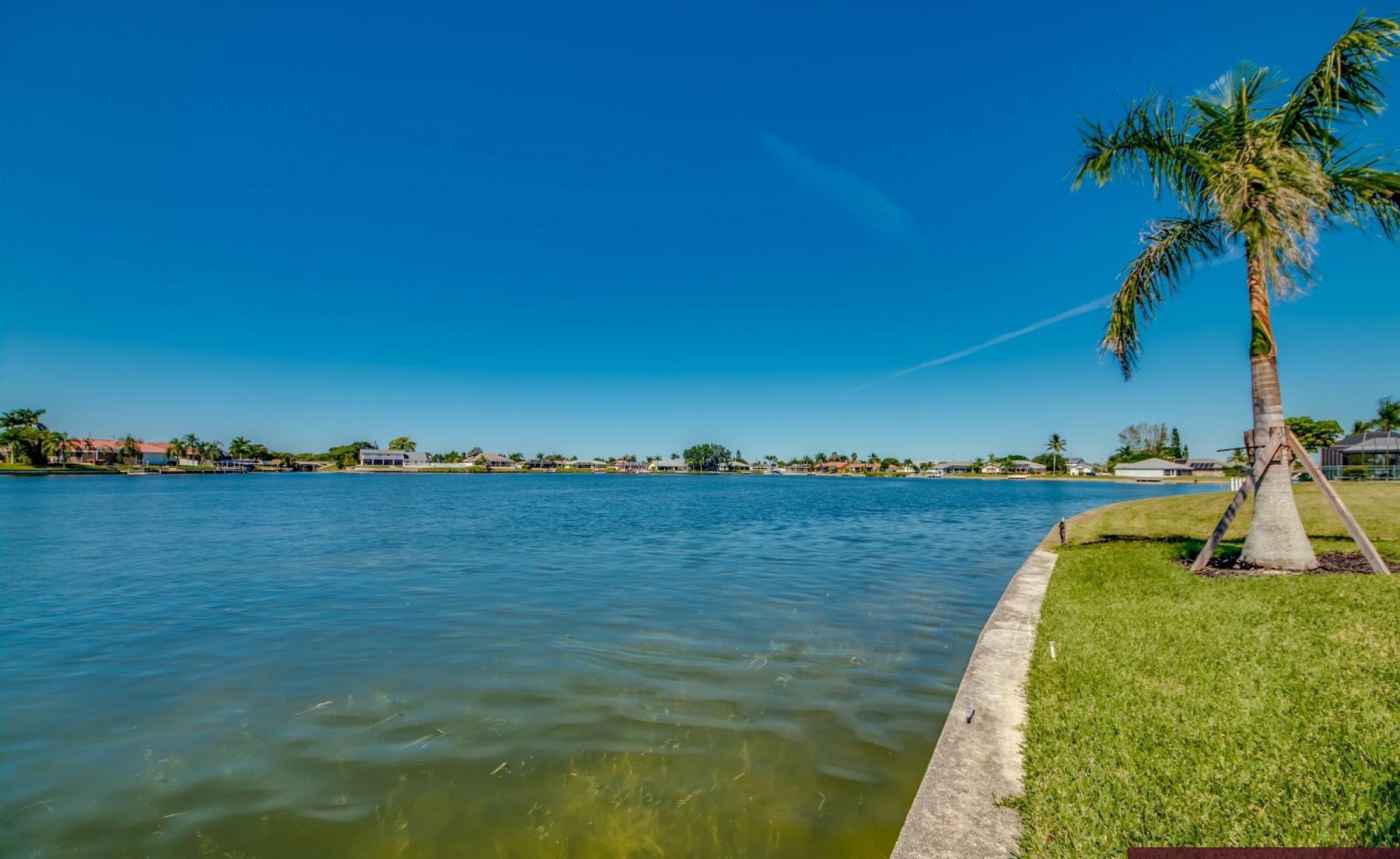 Beheizter Pool mit Sunledge und Blick auf den See bei Sonnenuntergang.