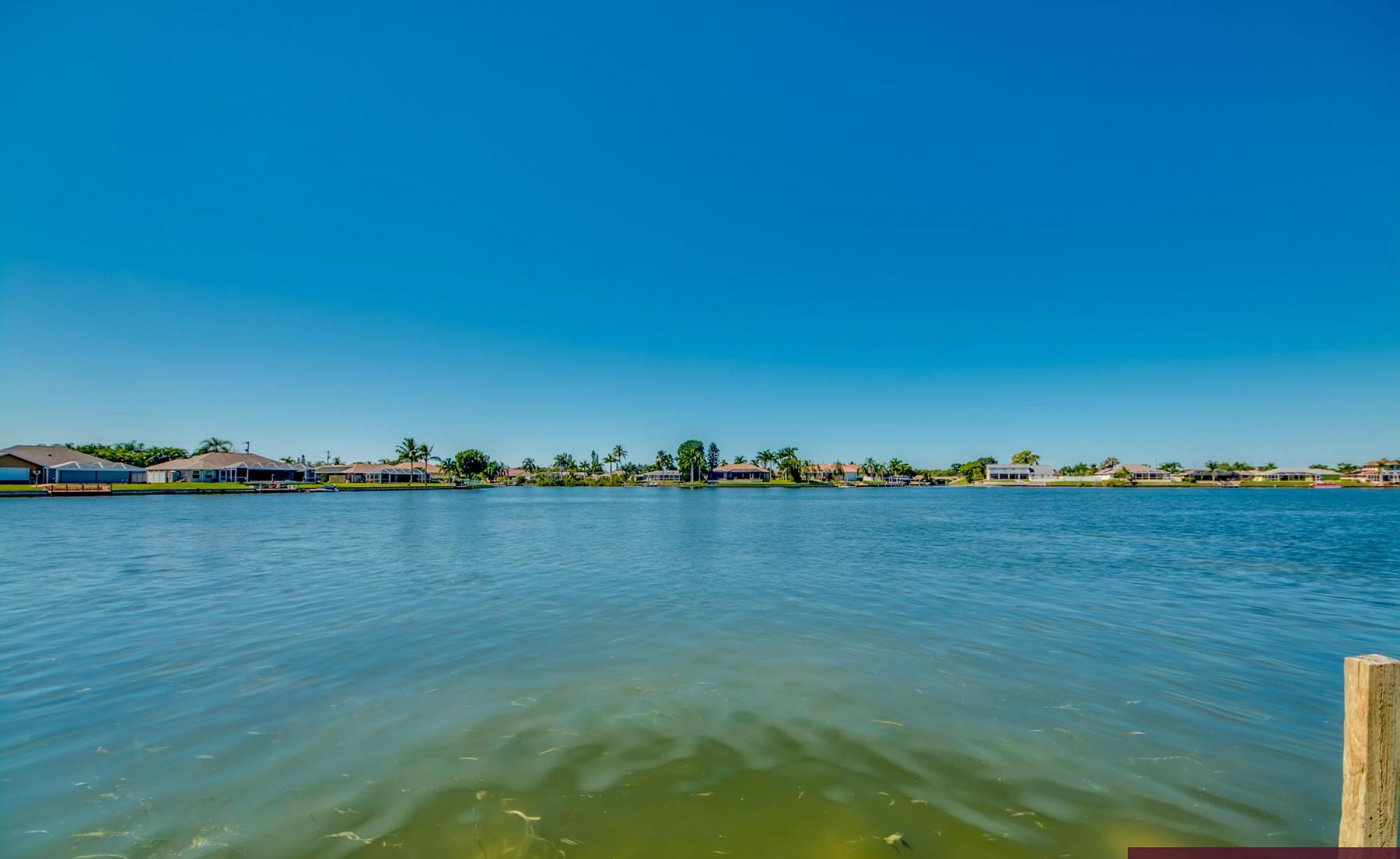 Beheizter Pool mit Sunledge und Blick auf den See bei Sonnenuntergang.
