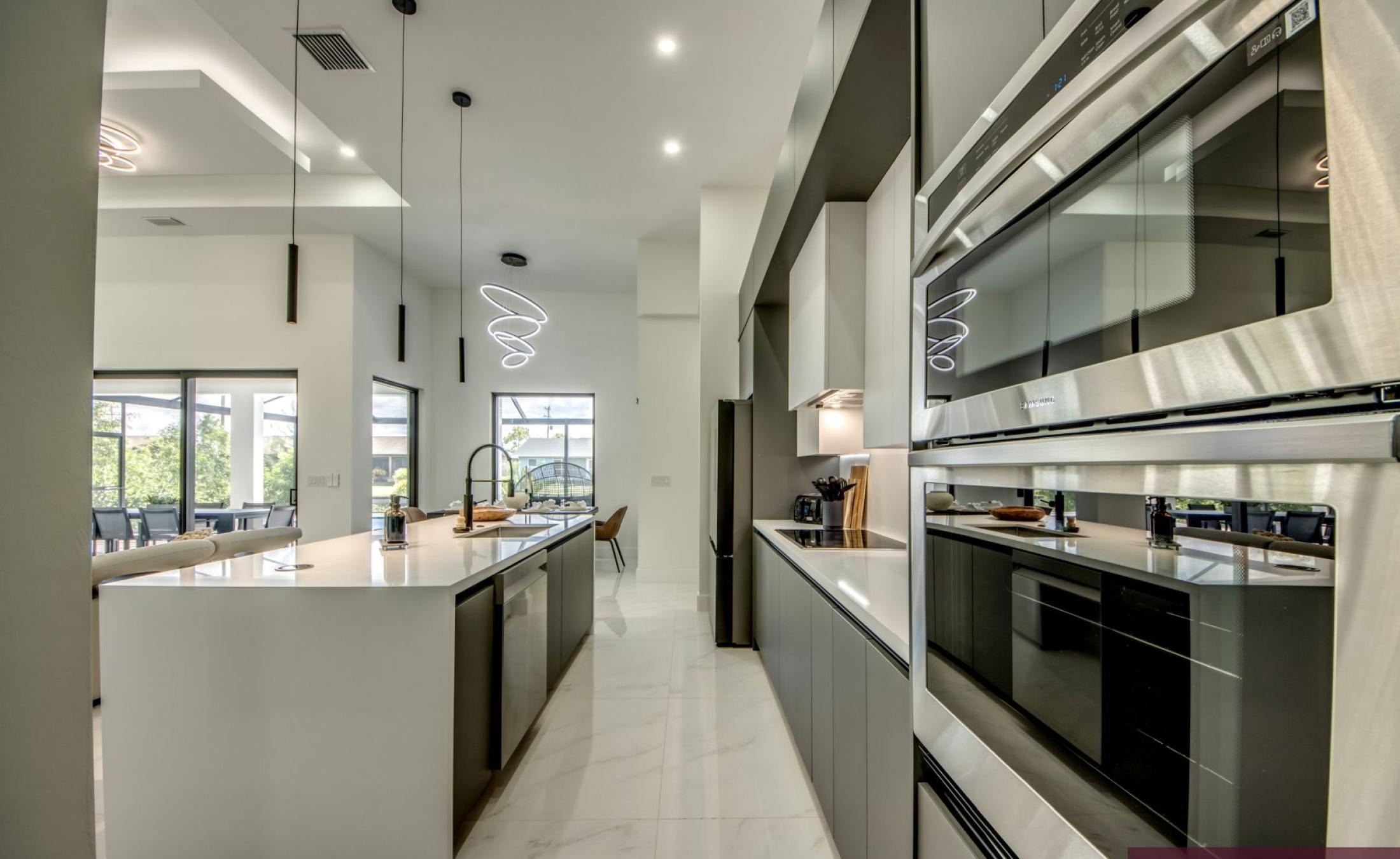 Beheizter Pool auf der Terrasse am Kanal mit Außenküche und TV-Bereich.