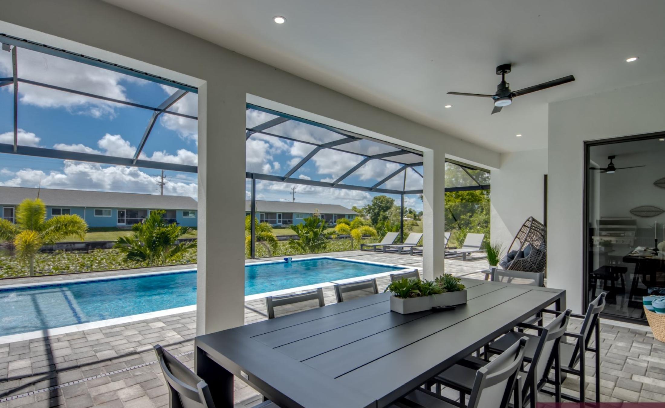 Poolterrasse mit beheiztem Pool am Kanal und Außenküche mit TV.