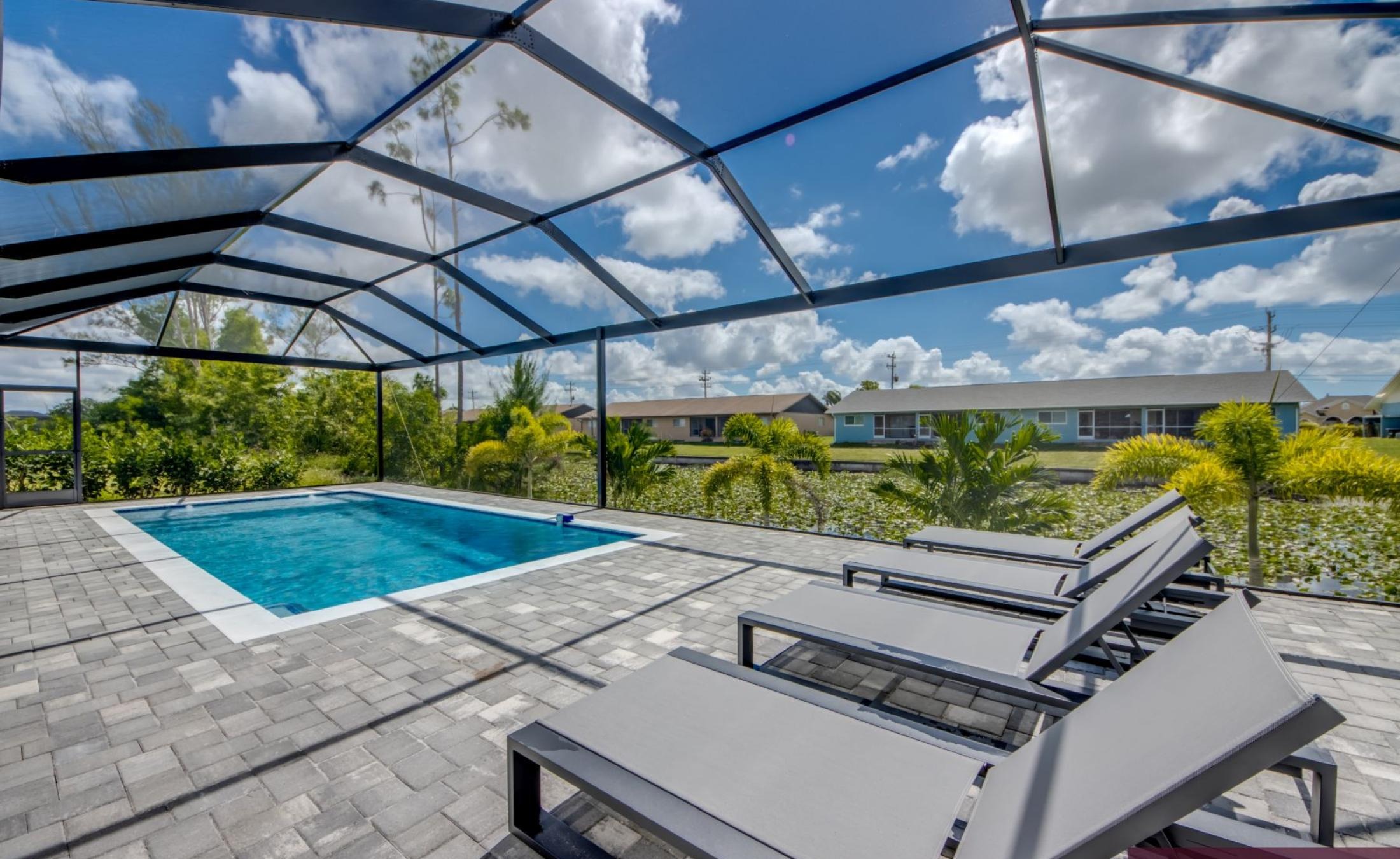 Poolterrasse mit beheiztem Pool, Außenküche und TV-Bereich am Kanal.