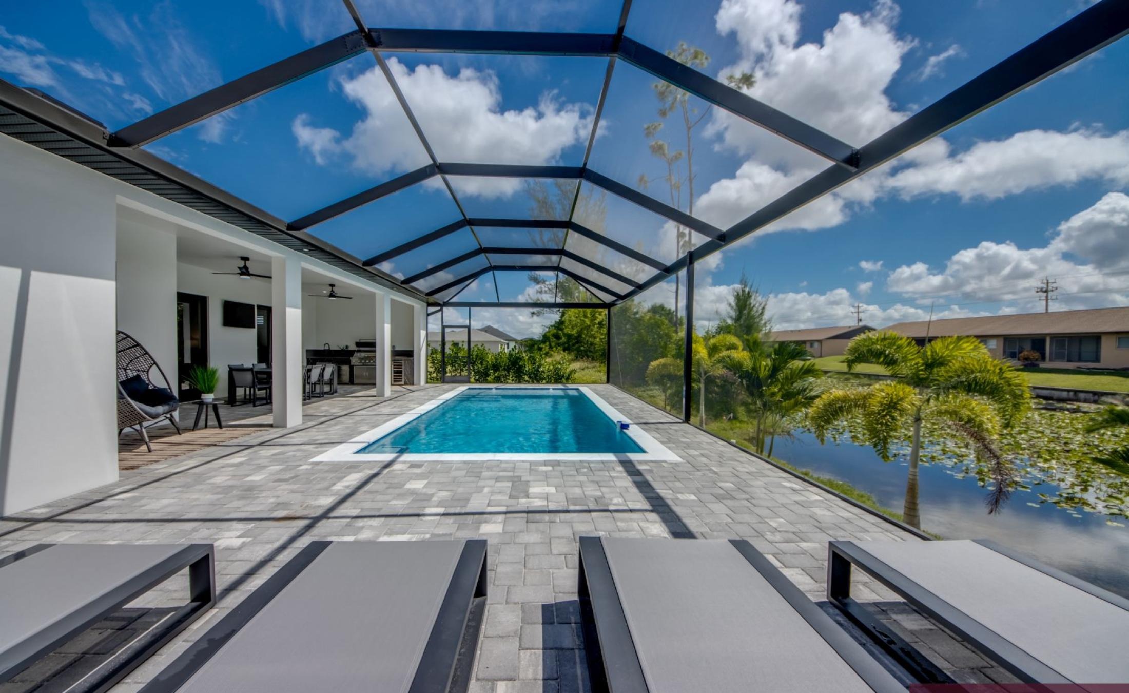 Überdachte Poolterrasse mit Sitzbereich und Fernseher im Außenbereich.