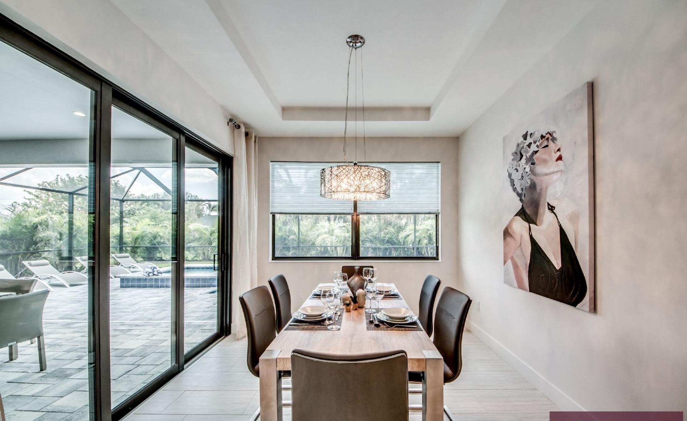 Heller Wohnbereich mit Sitzgruppe und Blick auf den Poolbereich.