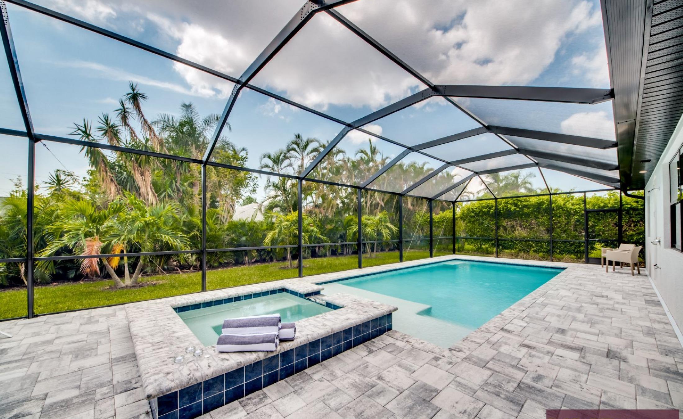 Heller Wohnbereich mit Sitzgruppe und Blick zum Poolbereich.