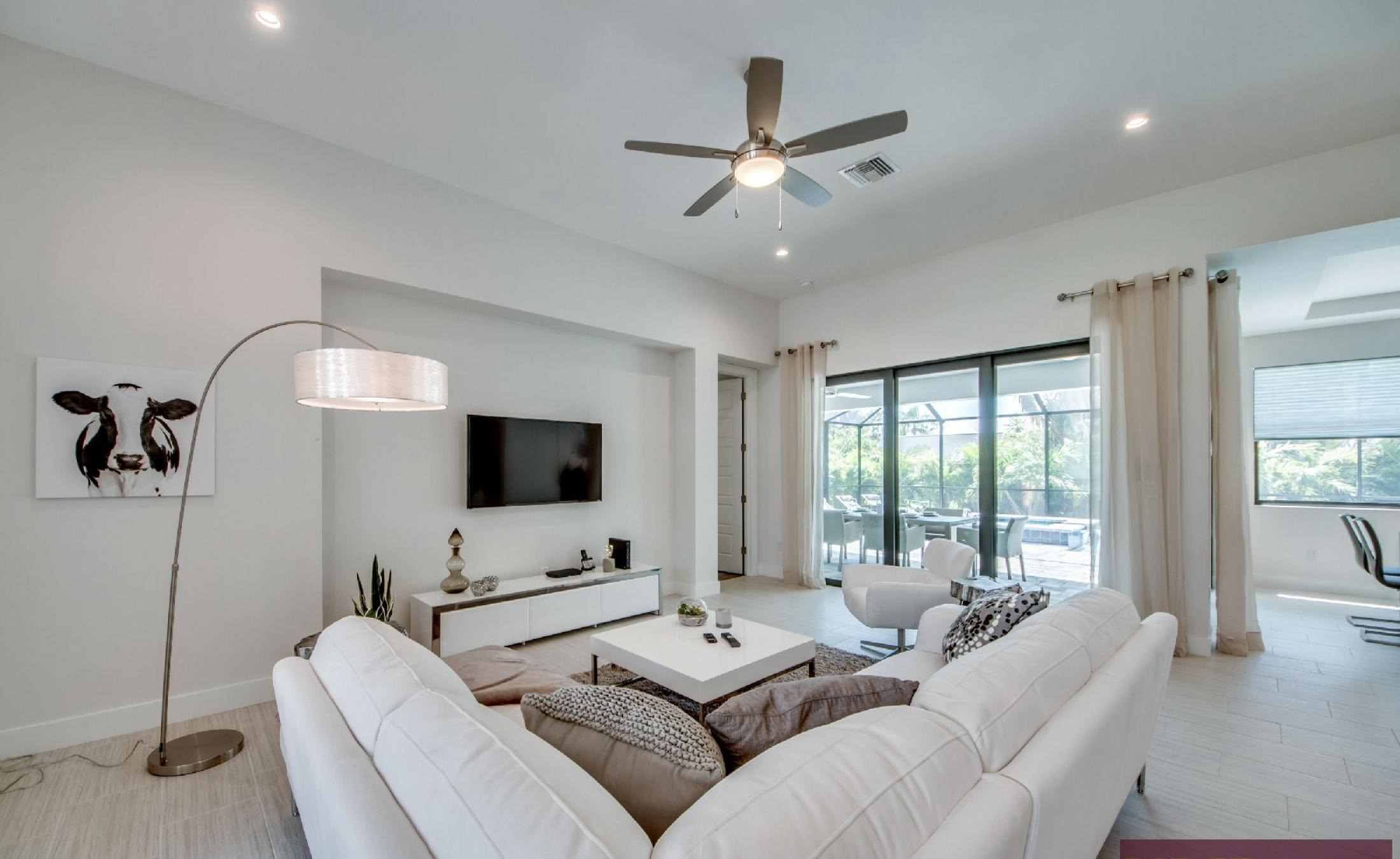 Helles Wohnzimmer mit Sitzbereich und Blick auf den Pool.