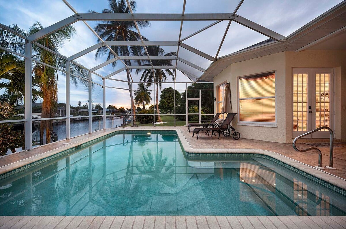 Beheizter Pool mit Sonnenliegen auf der Terrasse am Kanal.