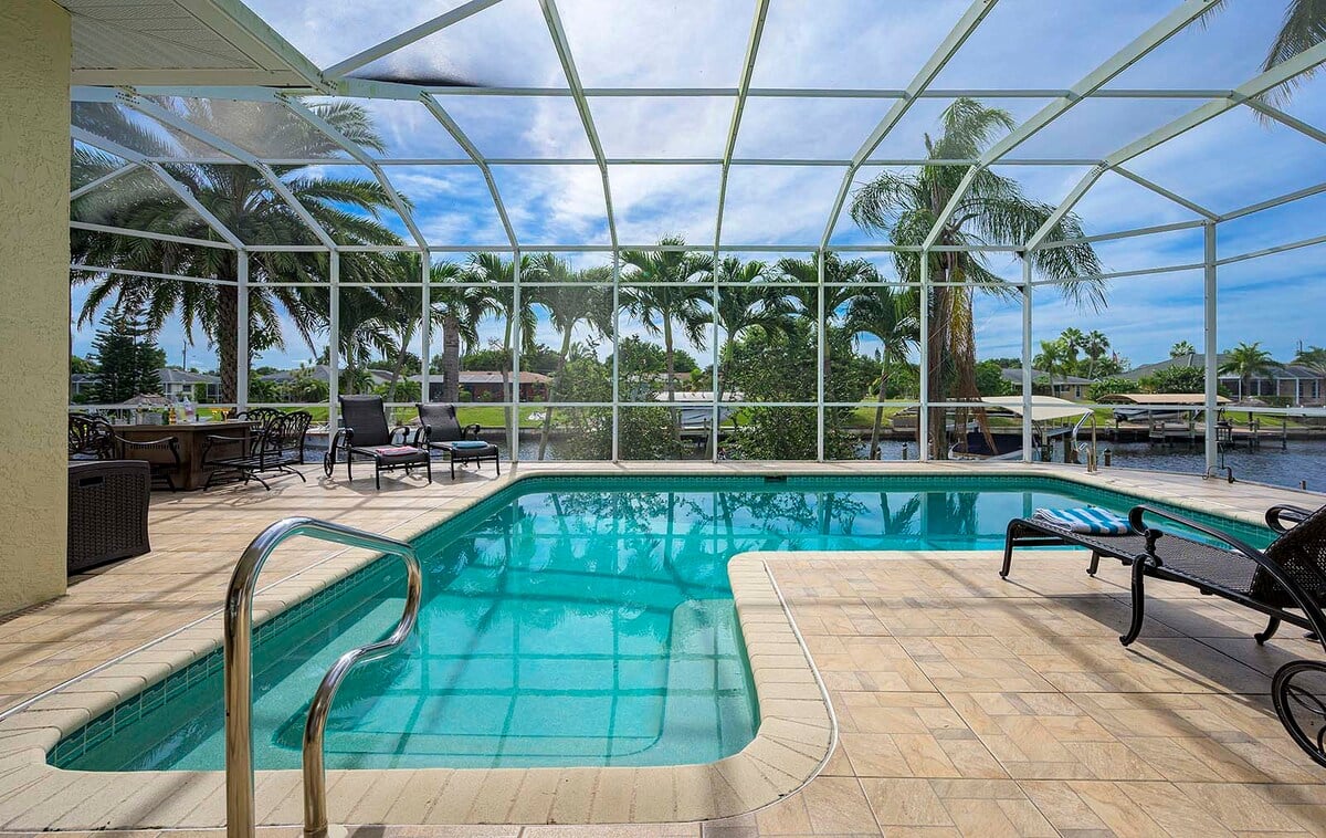 Beheizter Pool mit Sonnenliegen auf der Terrasse am Kanal.