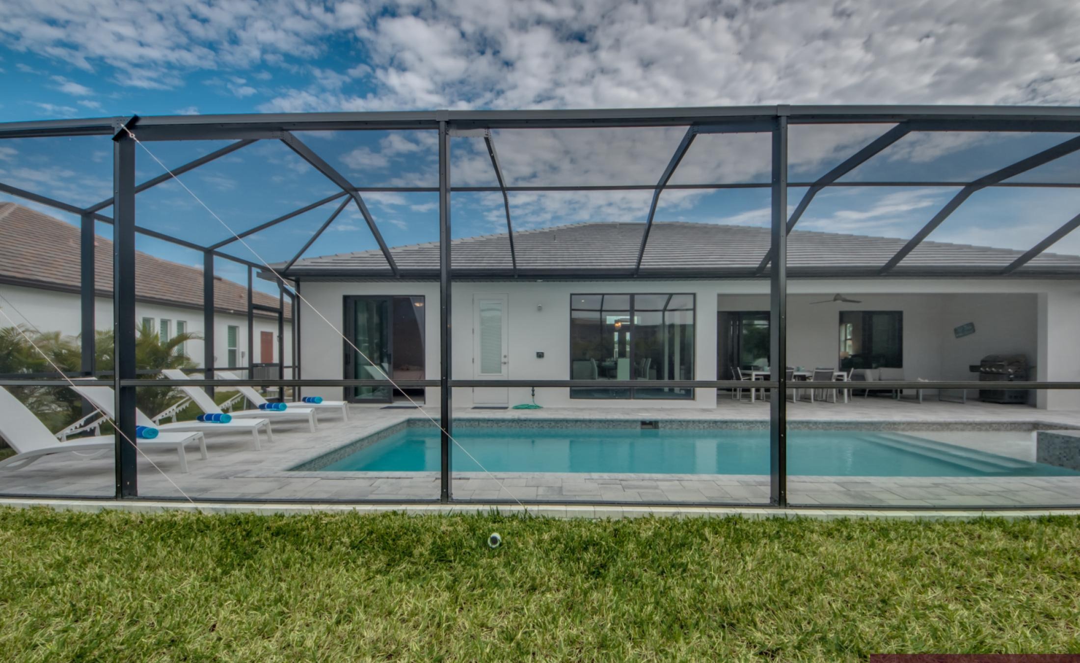 Moderner Poolbereich mit beheiztem Pool, Spa und Sonnenliegen bei Westausrichtung.