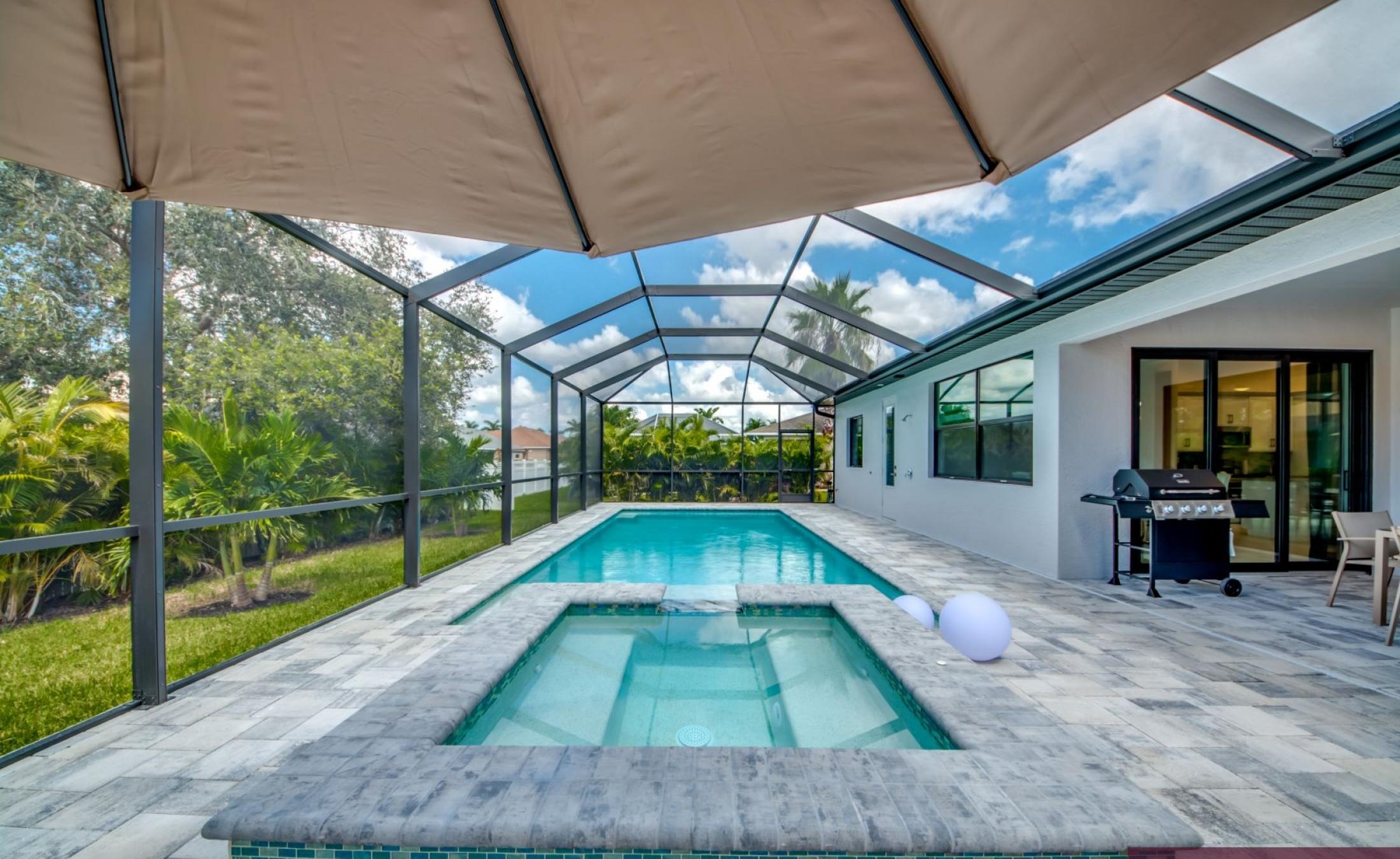 Große Sonnenterrasse mit beheiztem Pool und Spa bei Sonnenuntergang.