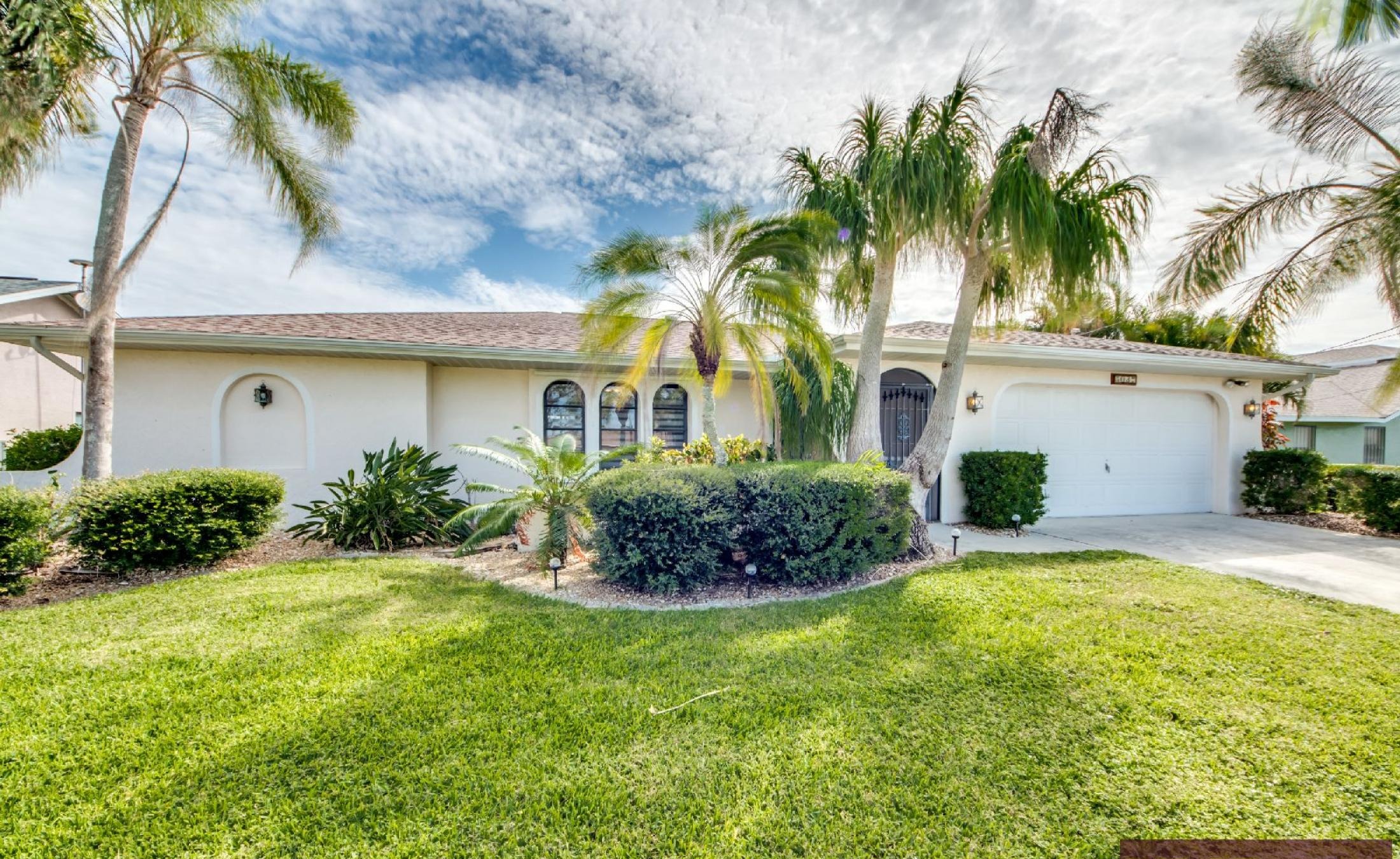 Villa am Kanal mit Bootsdock und Blick aufs Wasser.