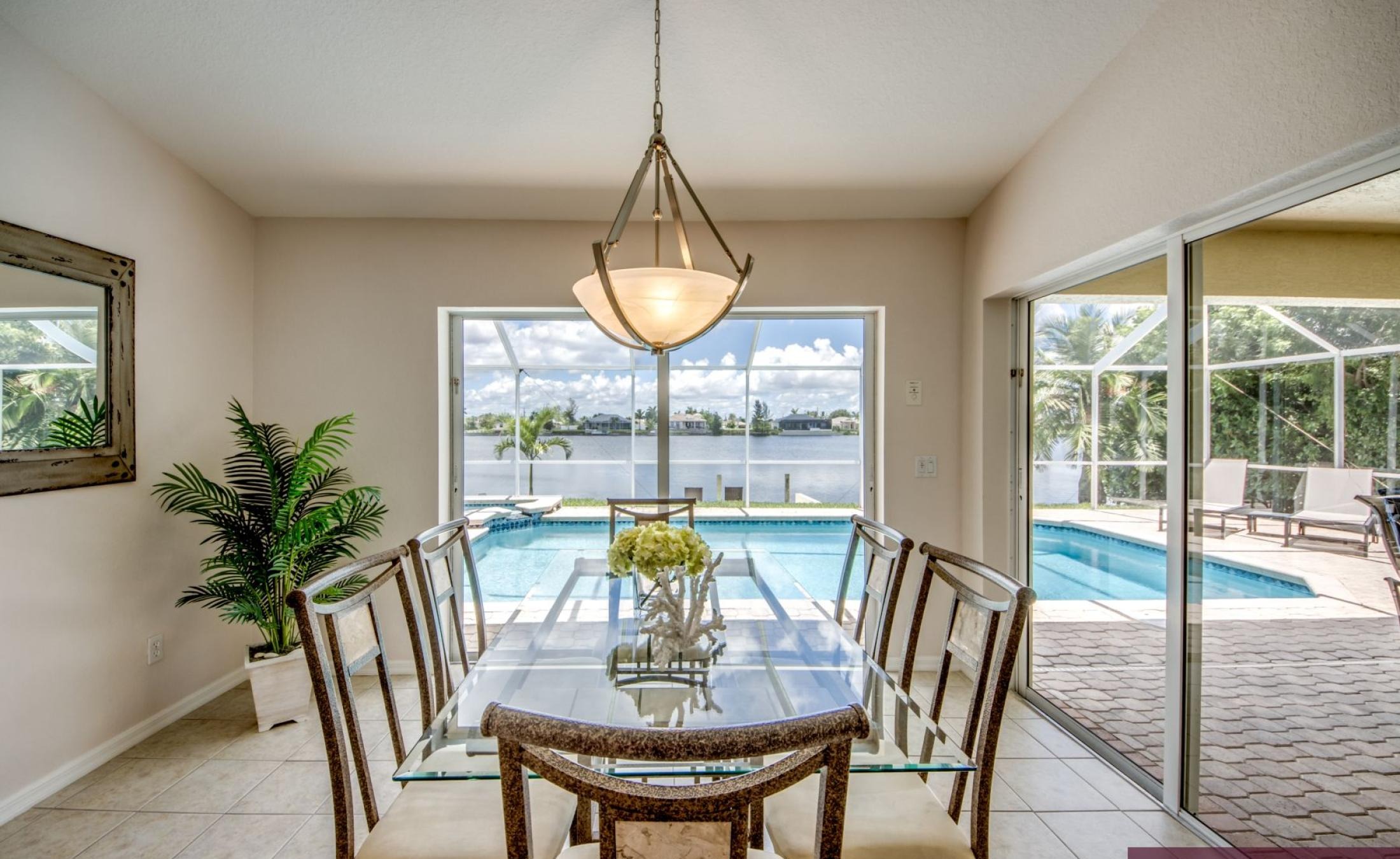 Terrasse am Kanal mit Blick aufs Wasser, Pool und Spa.