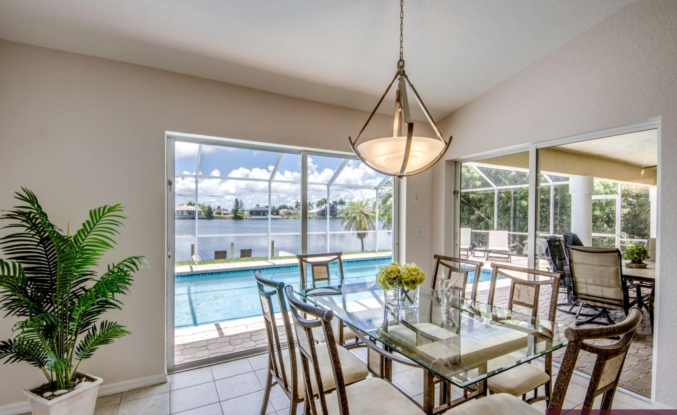 Große Poolterrasse mit beheiztem Pool, Spa und Blick auf den Kanal mit Bootsdock.