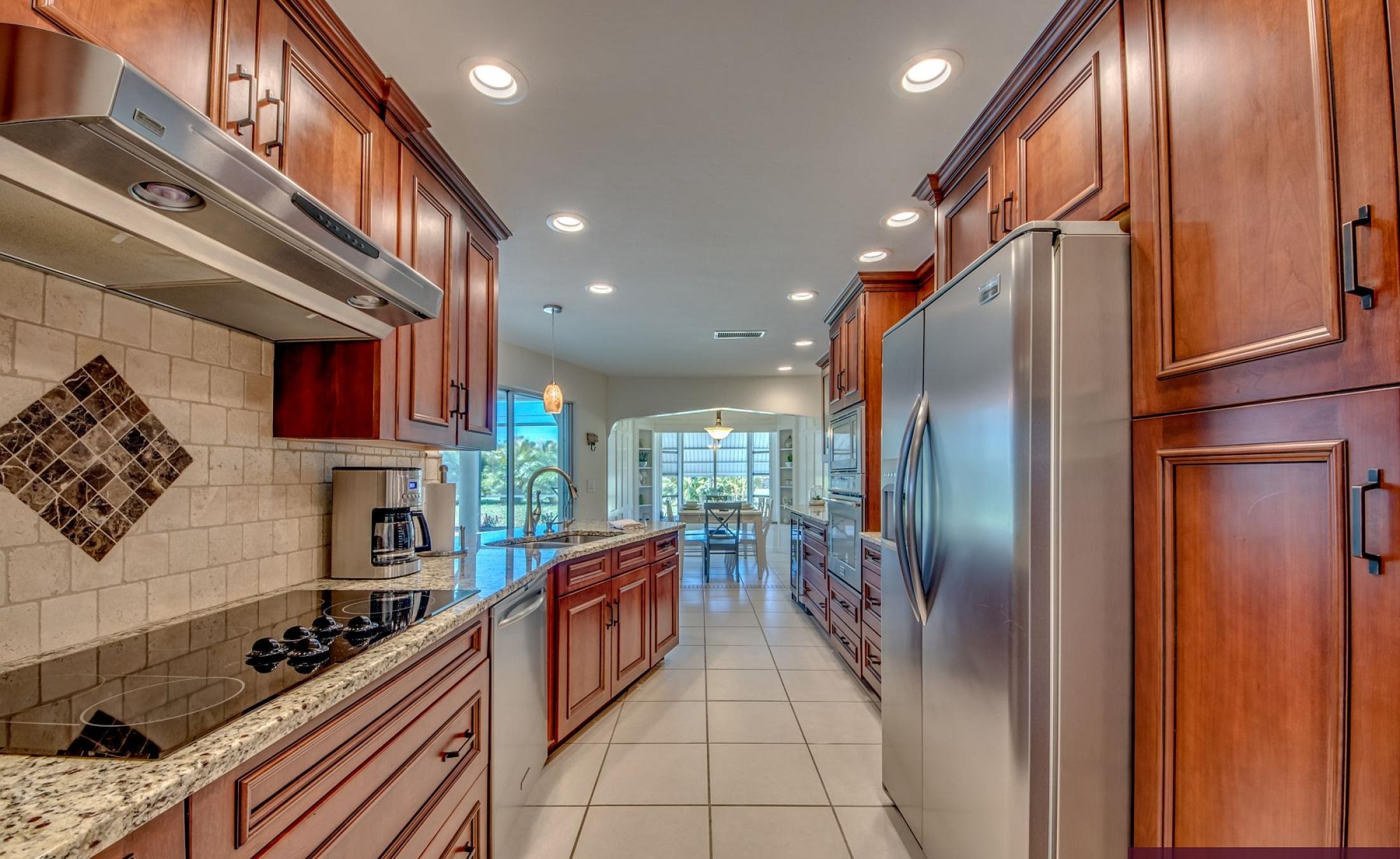 Moderne Villa mit sonniger Poolterrasse und großen Glasschiebetüren.