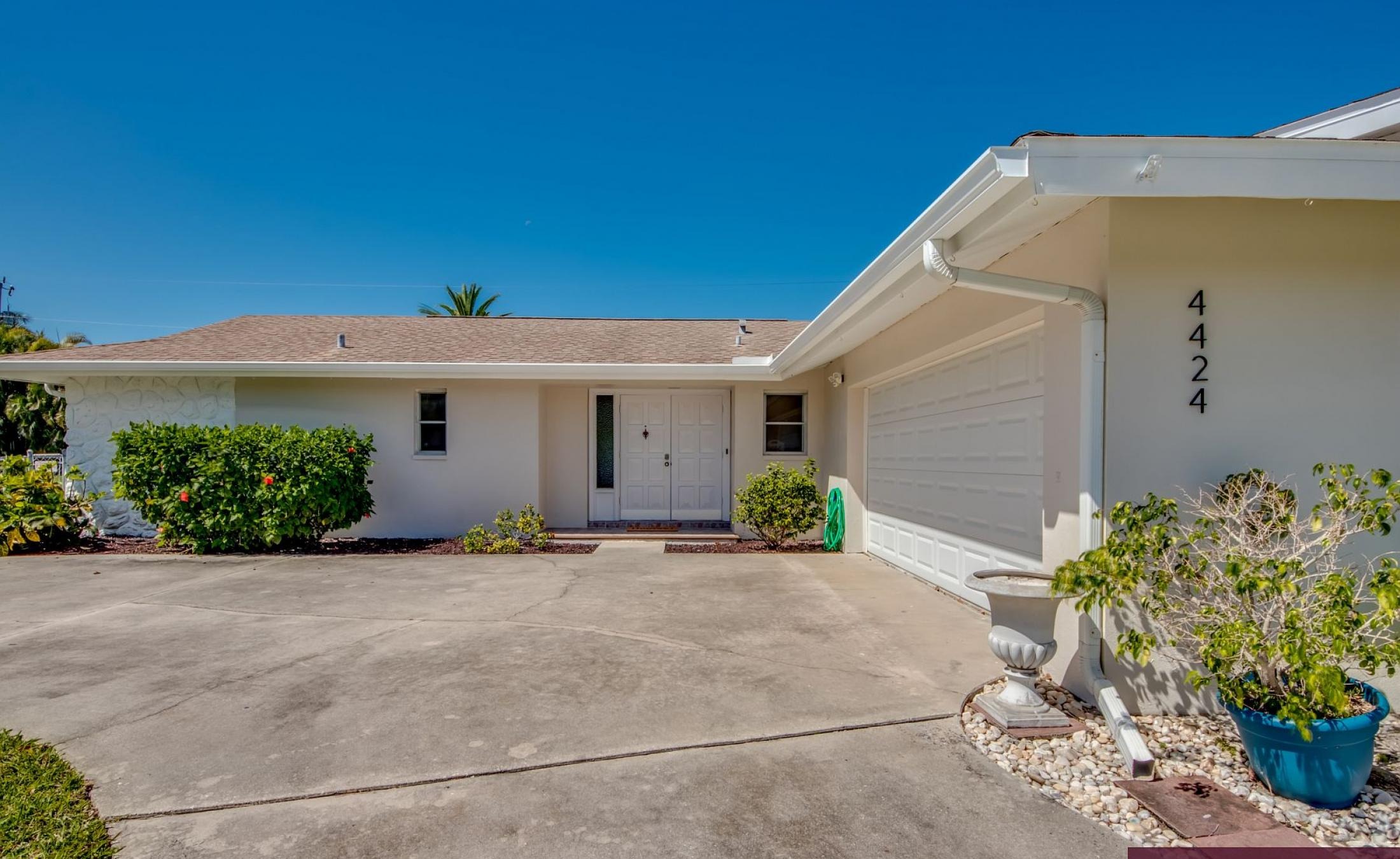 Moderne Villa mit großer Glasschiebetür zur sonnigen Poolterrasse.