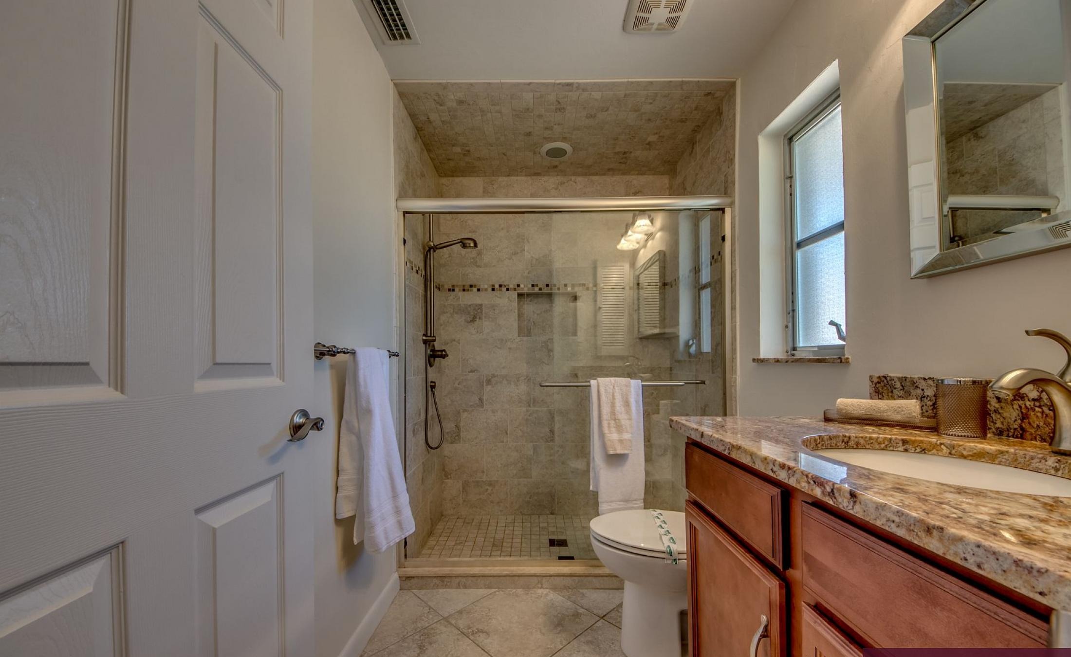 Moderne Villa mit großer Glasschiebetür zur sonnigen Poolterrasse.