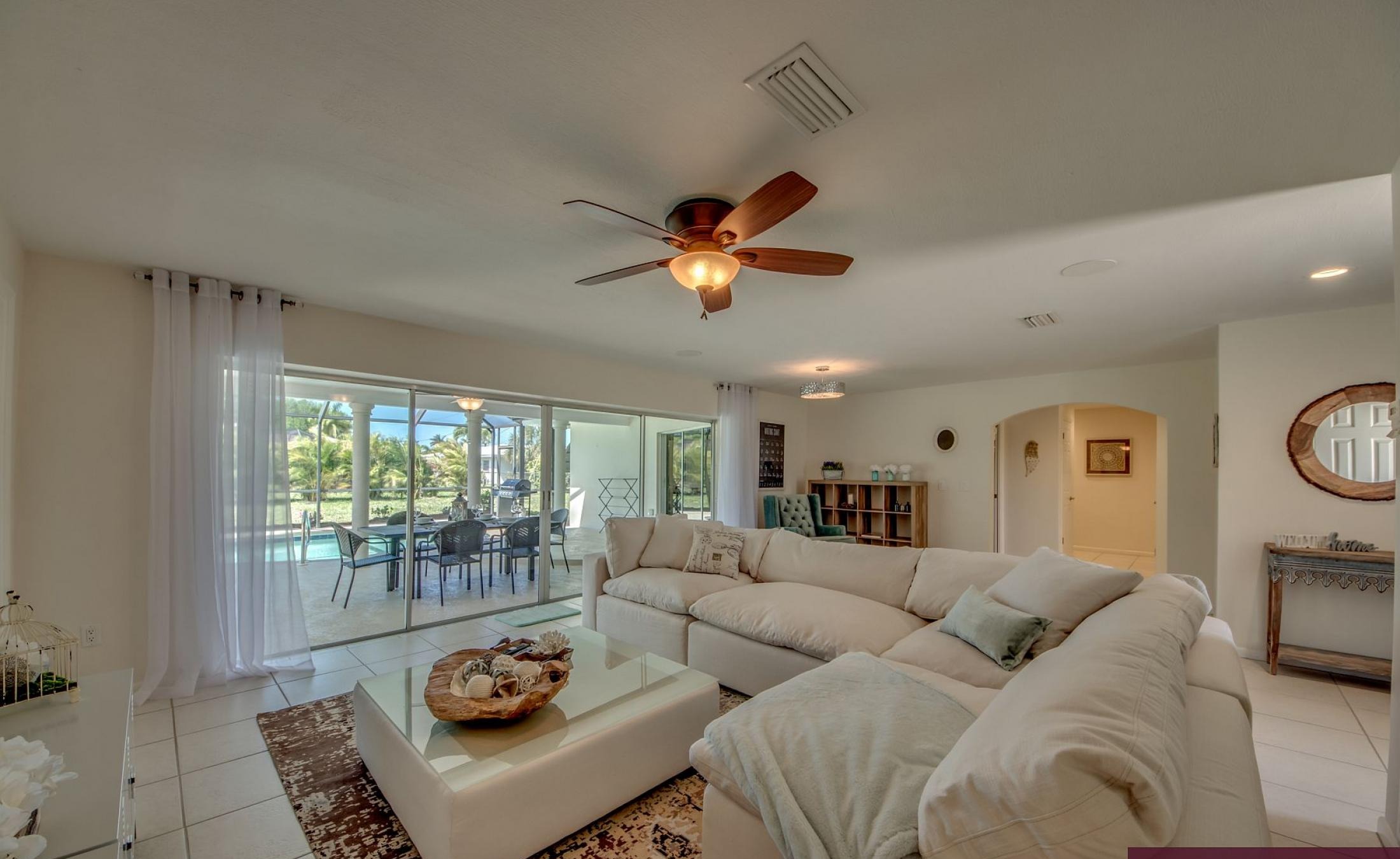 Moderne Villa mit großer Poolterrasse und Glasschiebetüren.