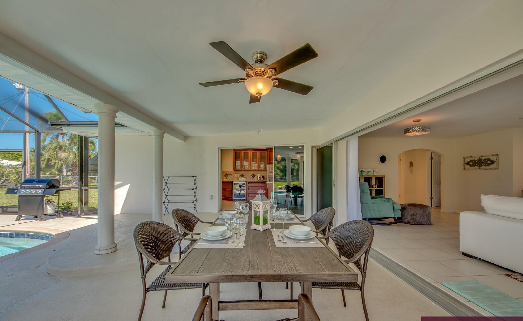 Moderne Villa in Cape Coral mit sonniger Poolterrasse und großen Glasschiebetüren.