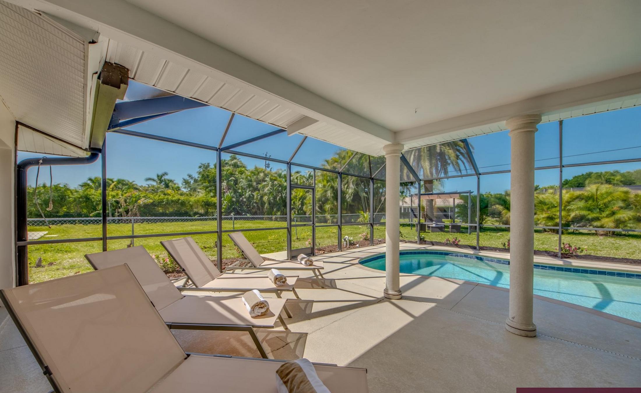 Sonnige Poolterrasse mit beheiztem Pool und Sitzbereich.
