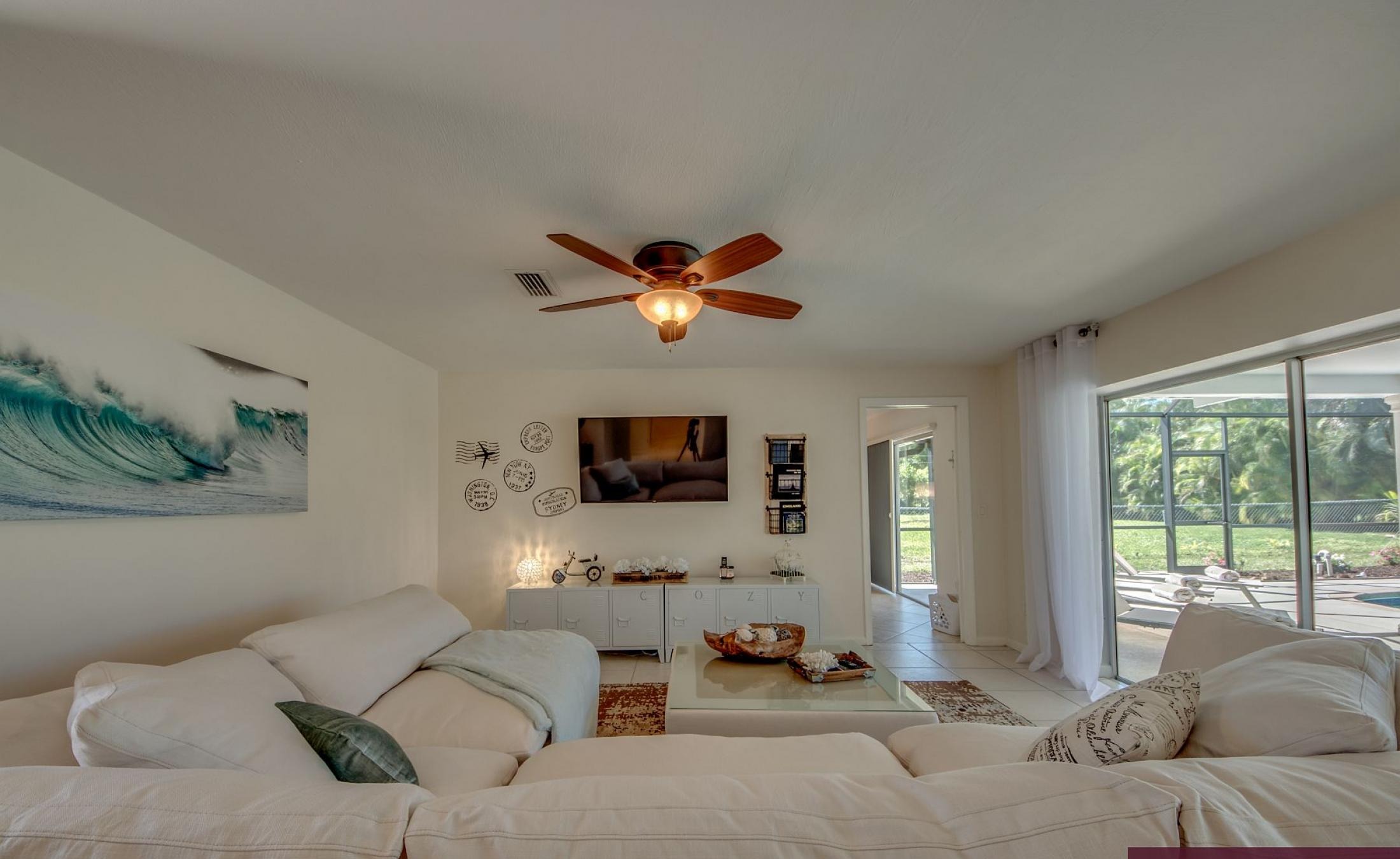 Moderne Villa mit sonniger Poolterrasse und großen Glasschiebetüren.