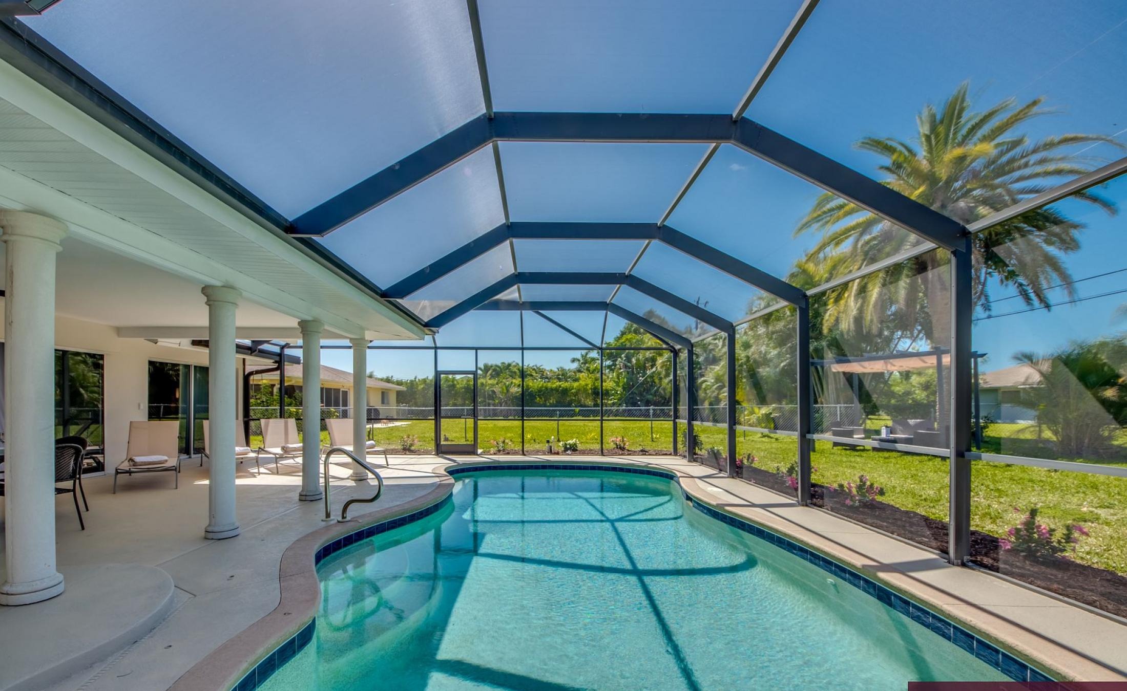 Sonnige Poolterrasse mit beheiztem Pool und Sitzbereich.