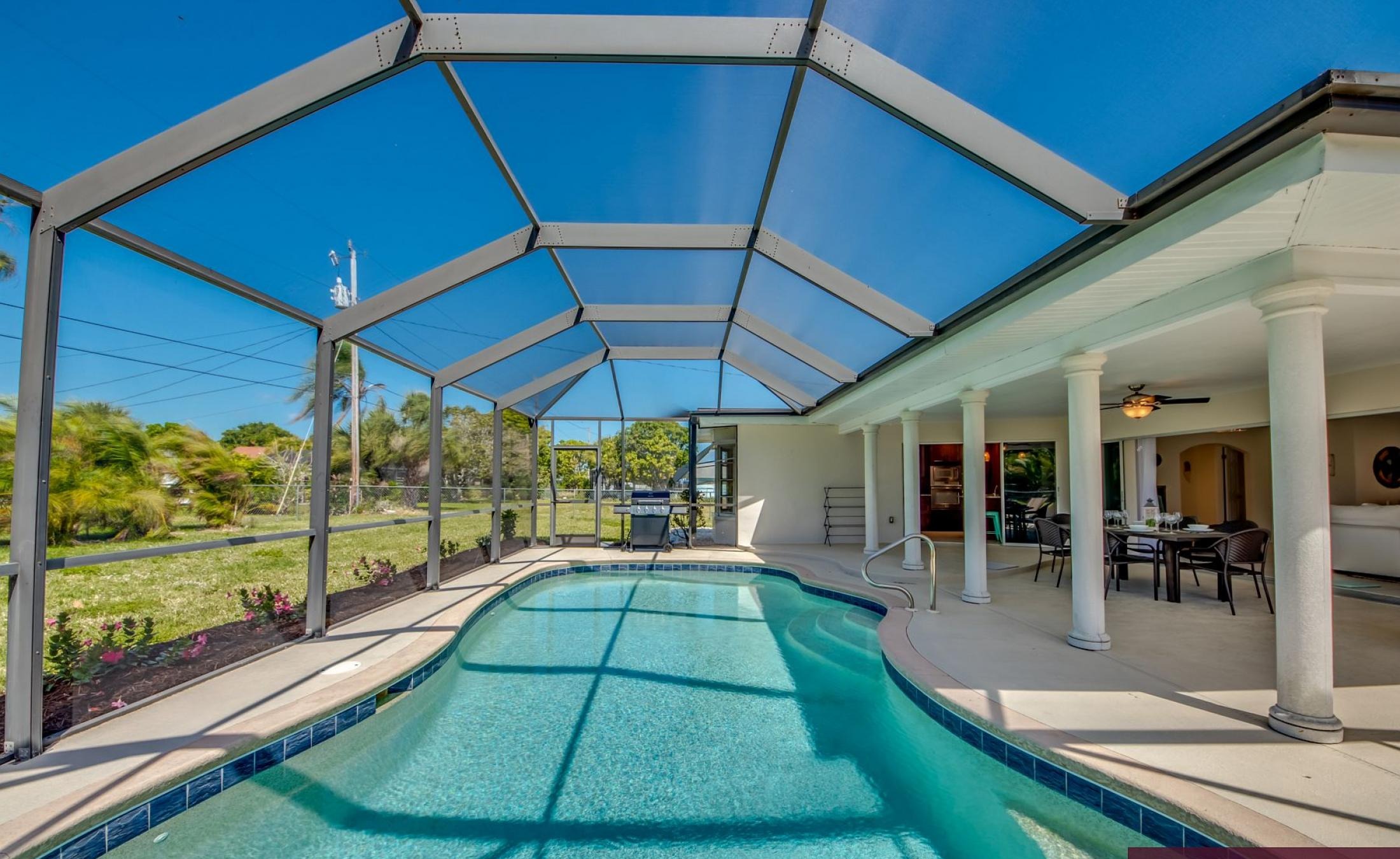 Sonnige Poolterrasse mit beheiztem Pool und Sitzbereich.
