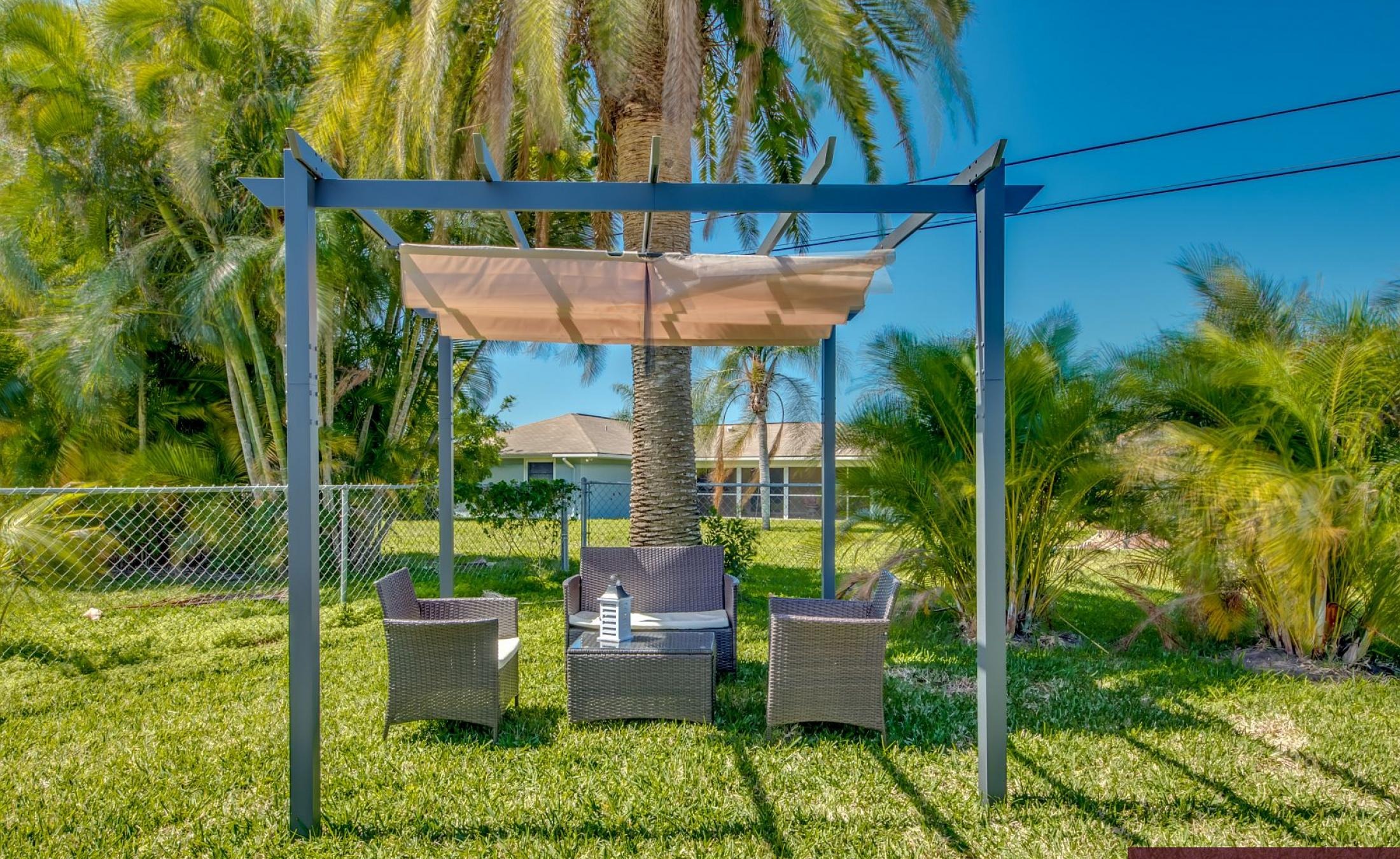 Moderne Villa mit sonniger Poolterrasse und großen Glasschiebetüren.