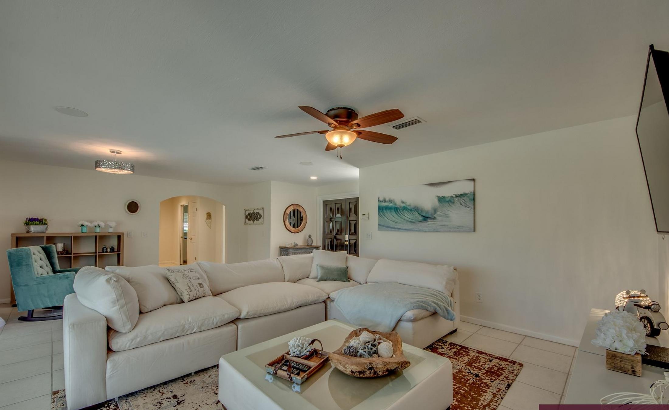 Offener Wohnbereich mit großen Glasschiebetüren zur Poolterrasse.