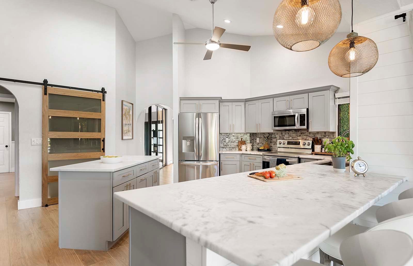 Barbereich an der Theke mit zusätzlichen Sitzgelegenheiten und Blick auf das Wohnzimmer und die Veranda