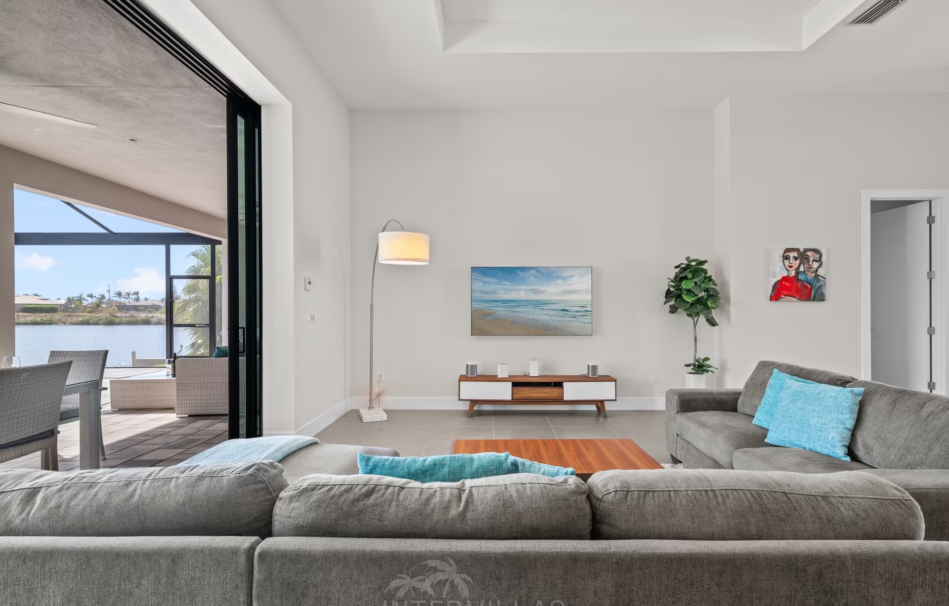 Überdachter Terrassenbereich mit Gasgrill, Sitzgruppe und Blick auf den Kanal.