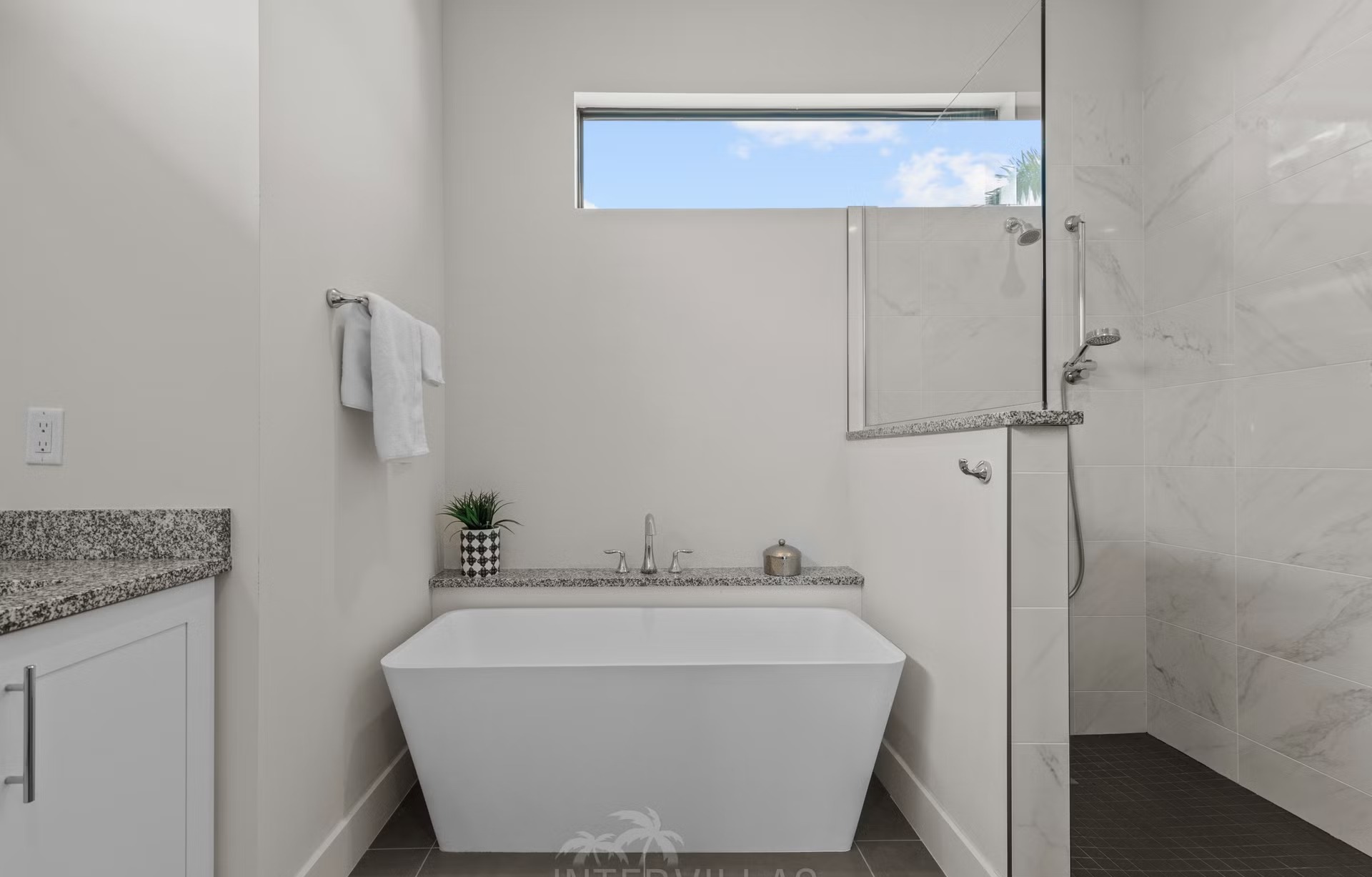 Überdachter Sitzbereich am Pool mit Liegen und Gartenmöbeln.