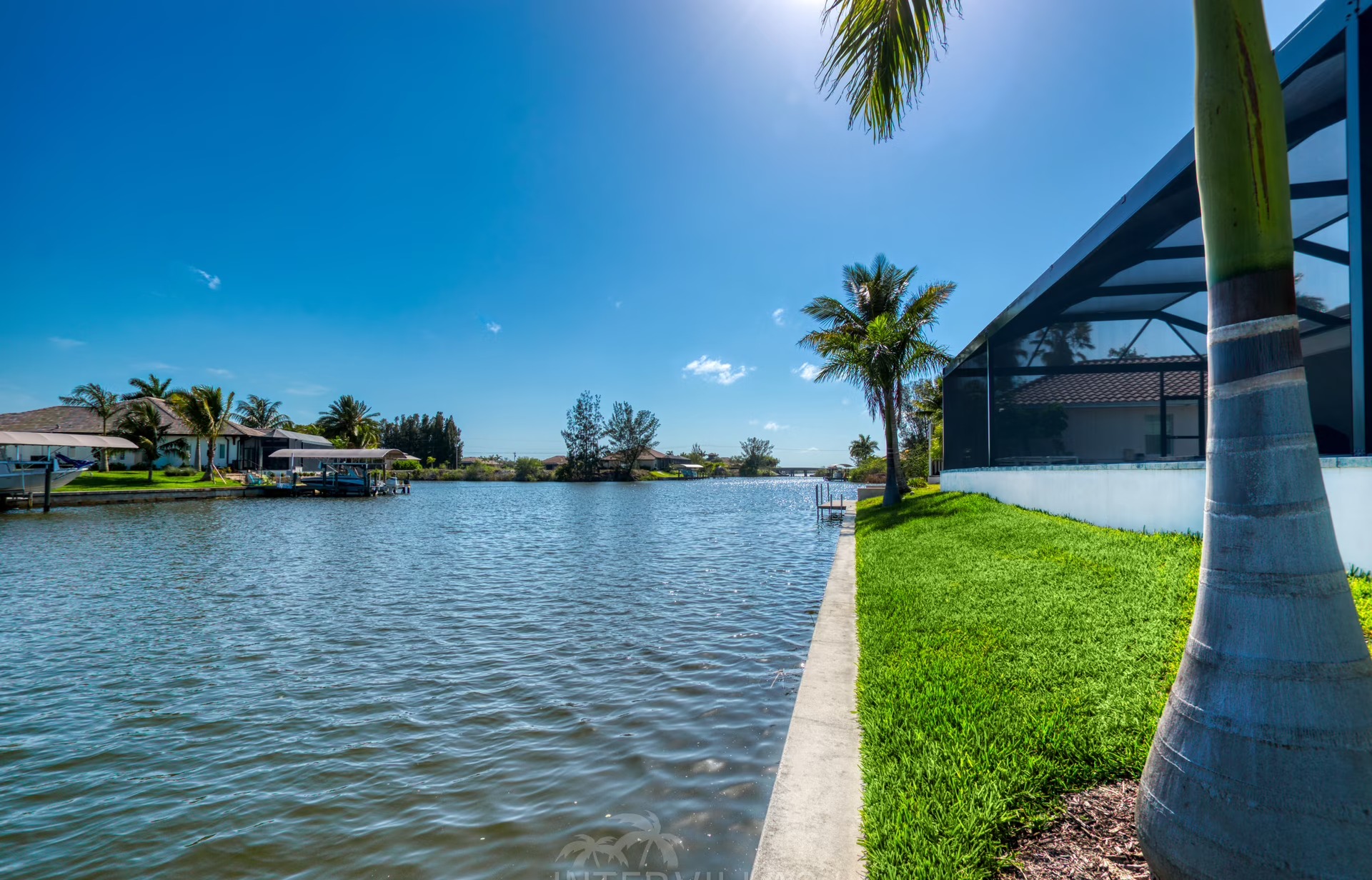 Überdachter Außenbereich mit Gasgrill und Sitzmöbeln am Pool.