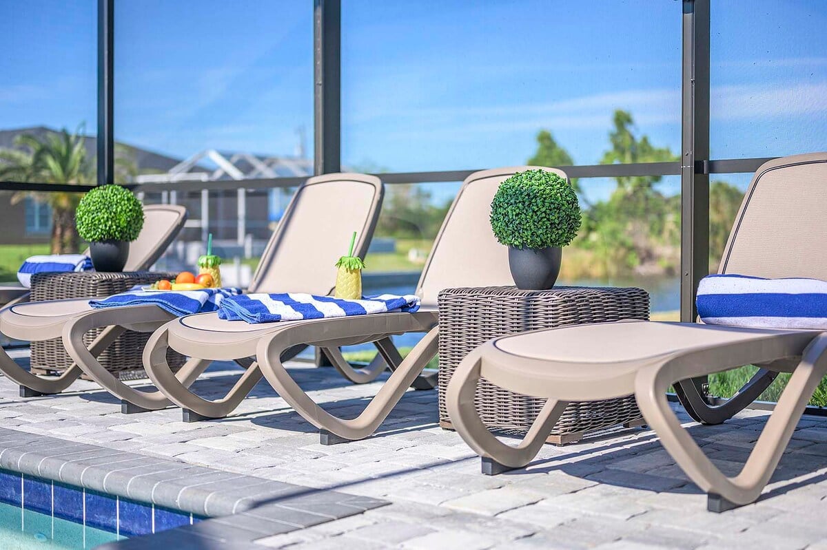 Beheizter Pool mit Sonnenliegen auf der Terrasse am Kanal.