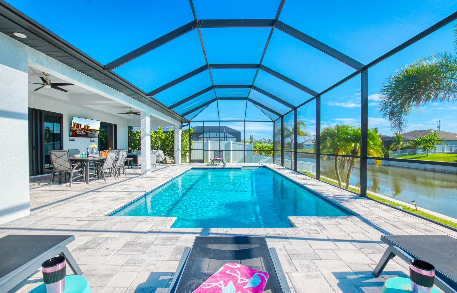 Moderne Villa am Kanal mit beheiztem Pool und Lanai bei Sonnenuntergang.