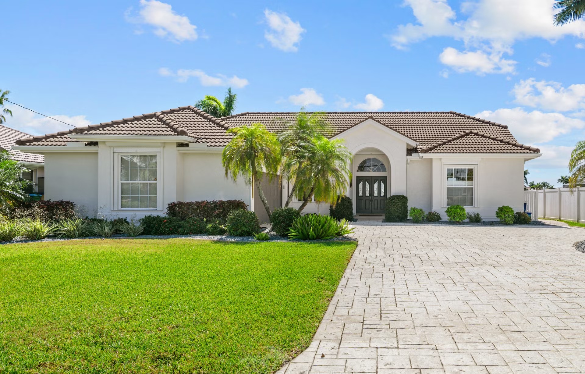 Überdachte Lanai mit Sitzbereich, Outdoor-Küche und Blick auf Kanal und Pool.