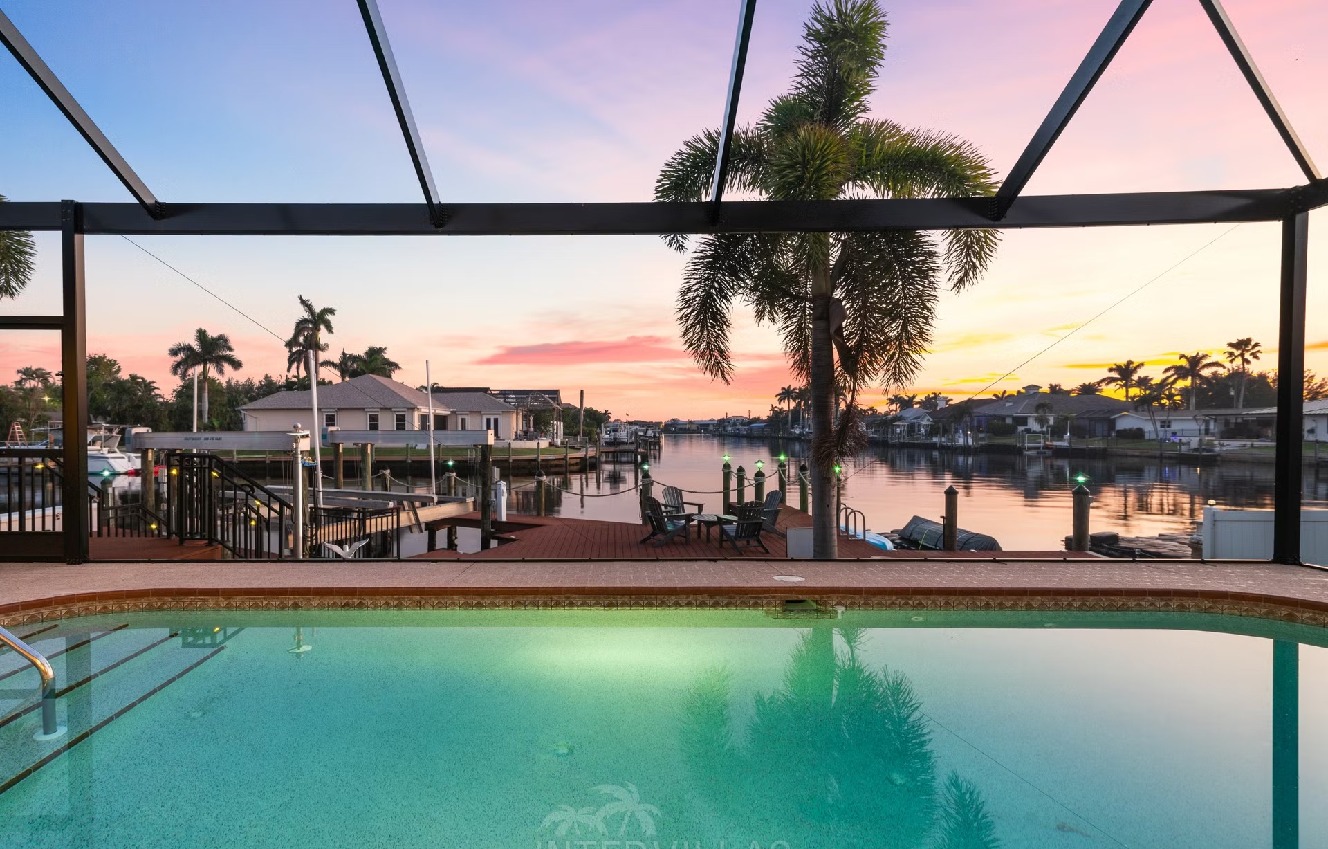 Überdachte Lanai mit Sitzbereich, Outdoor-Küche und Blick auf den Kanal.