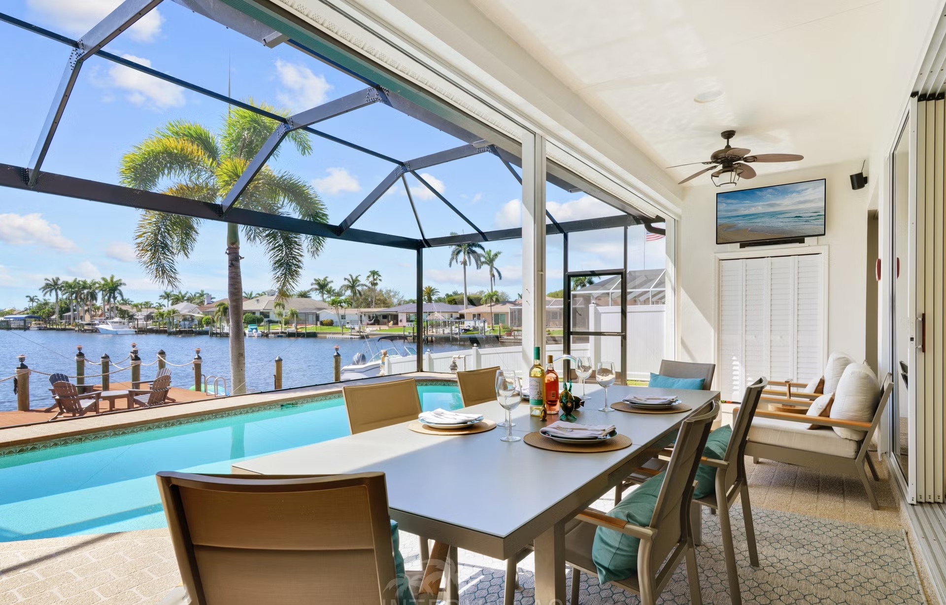 Überdachte Lanai mit Sitzbereich, Outdoor-Küche und Blick auf den Kanal.