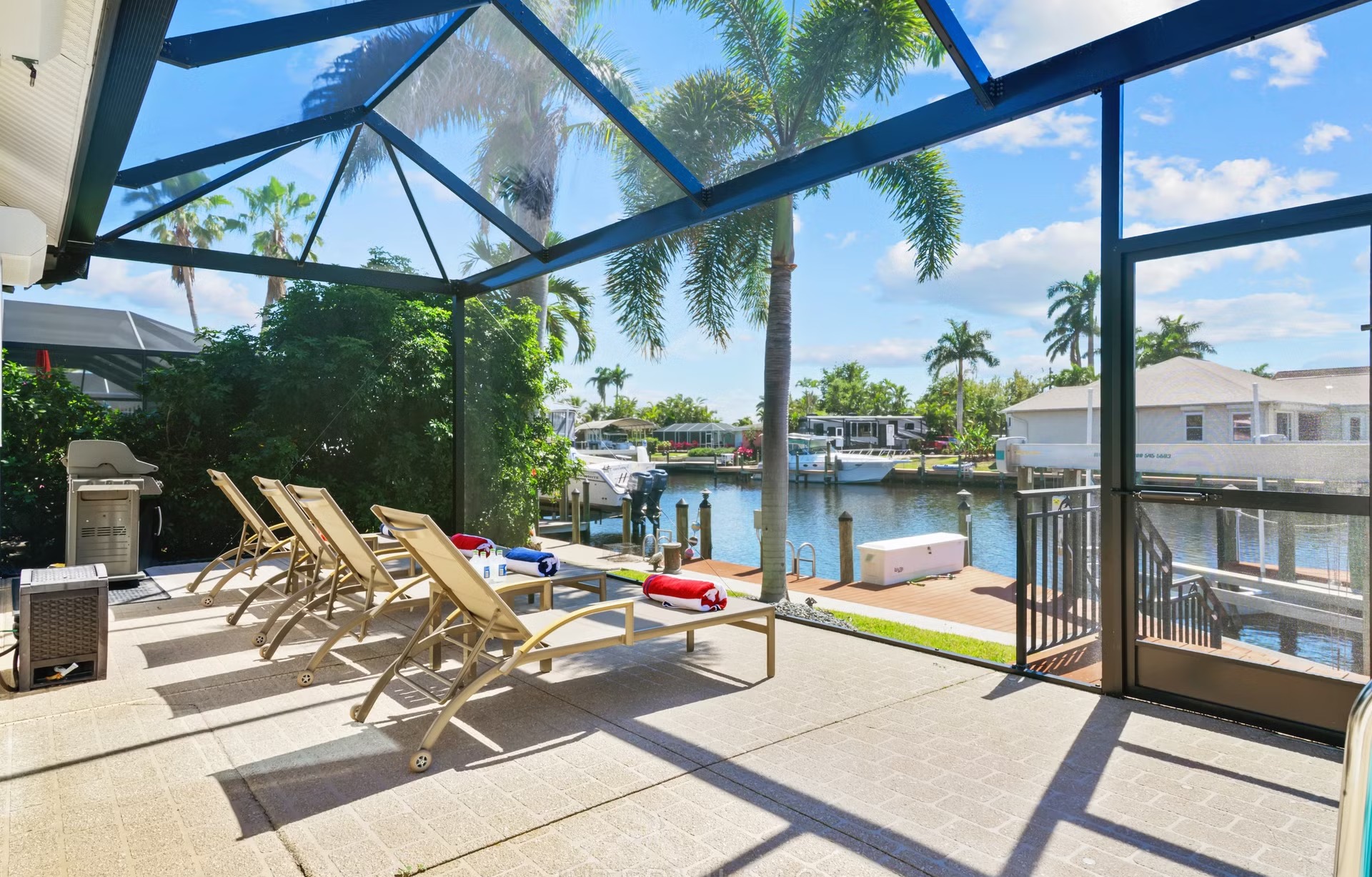 Überdachte Lanai mit Sitzbereich, Outdoor-Küche und Blick auf den Kanal.