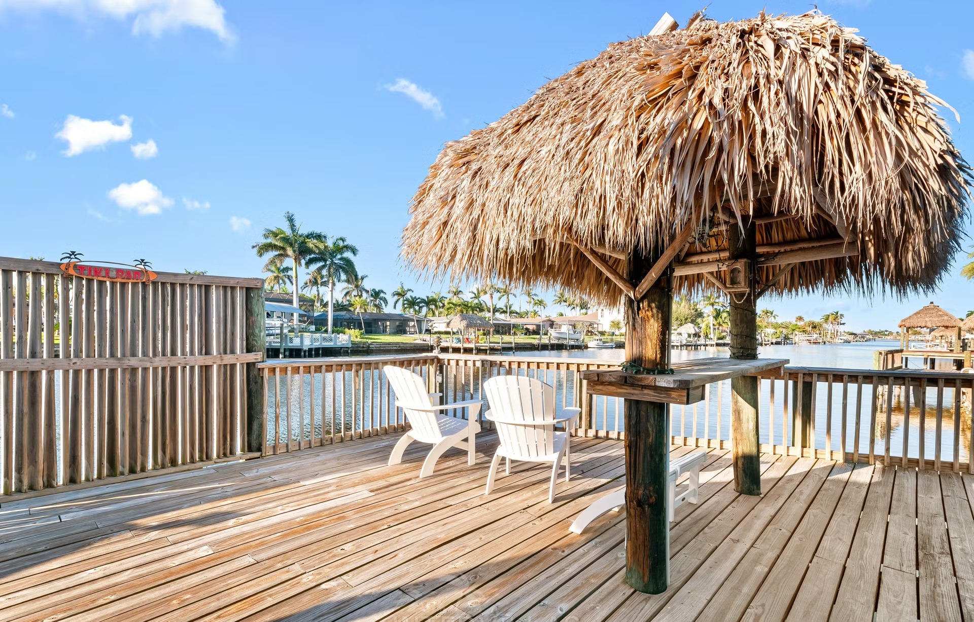 Bootsdock am Kanal mit Tiki-Hut und Sitzbereich.