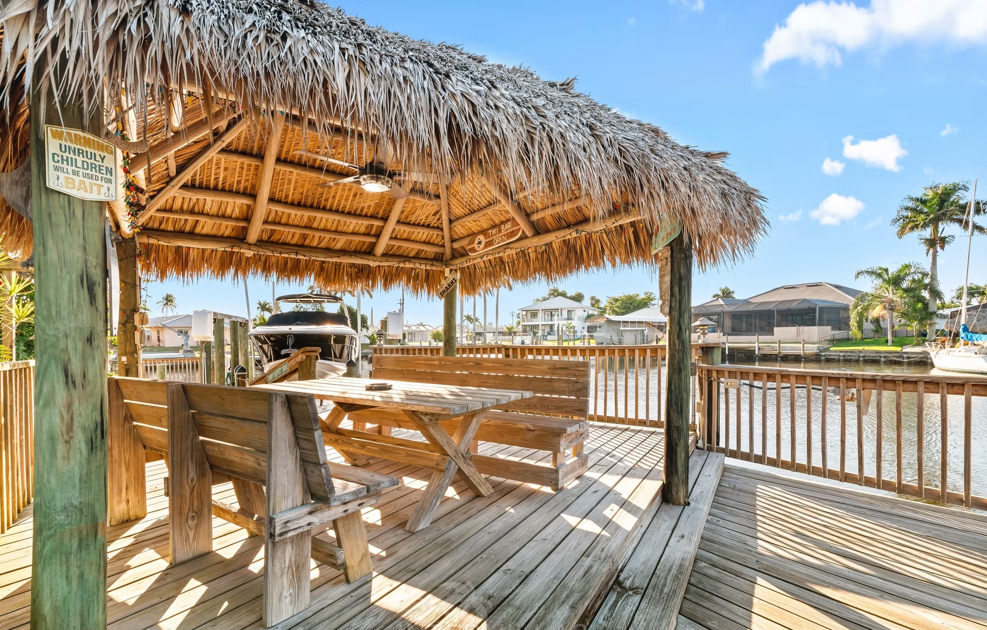 Bootsdock am Kanal mit Tiki Hut und Sitzbereich.