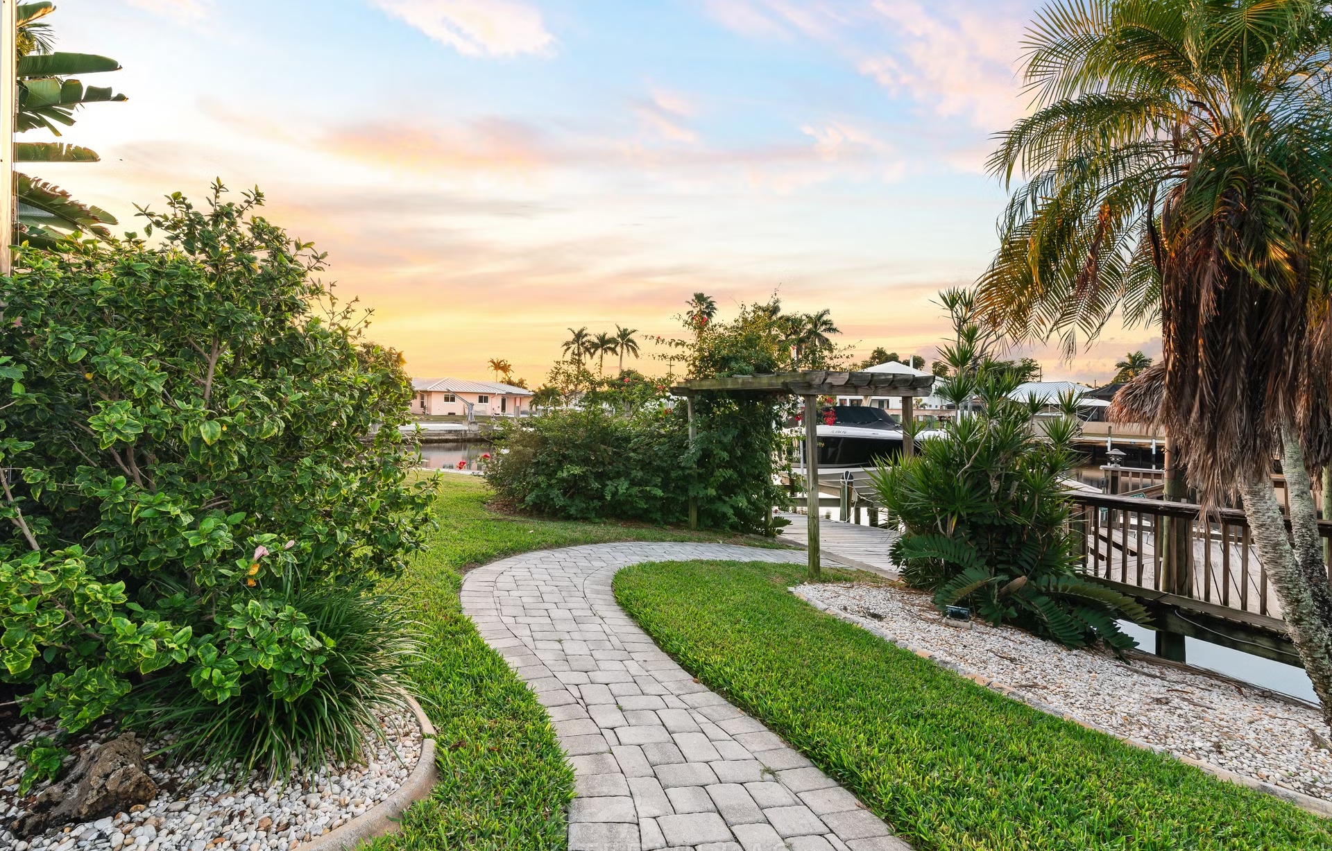 Privates Bootsdock am Kanal mit Tiki-Hut und Sitzbereich.