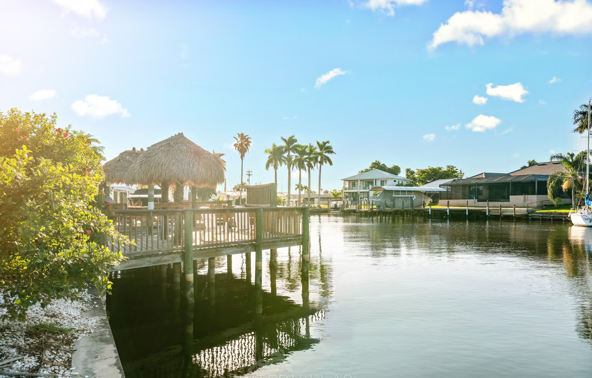 Bootsdock am Kanal mit Tiki-Hut und Sitzbereich.