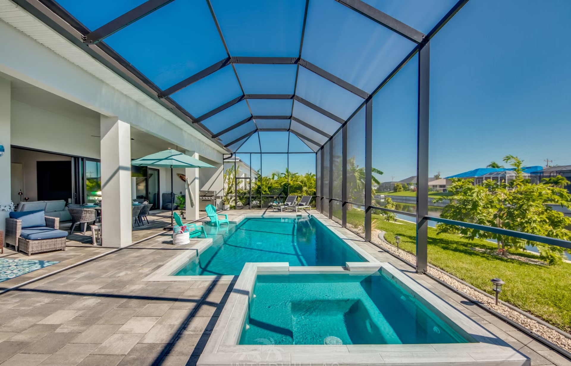 Salzwasserpool mit Spa und Sonnenliegen am Kanal, BBQ-Bereich im Außenbereich.