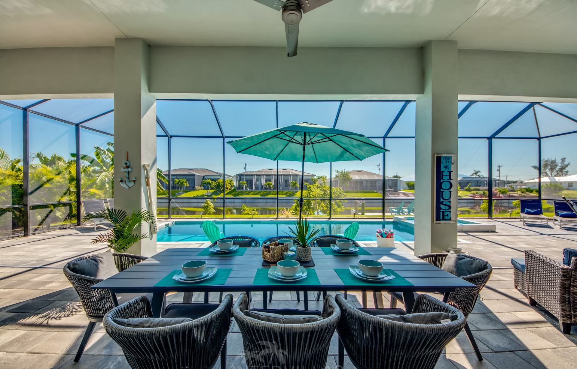 Salzwasserpool mit Spa und Liegen am Kanal, daneben Gasgrill und Outdoorküche.