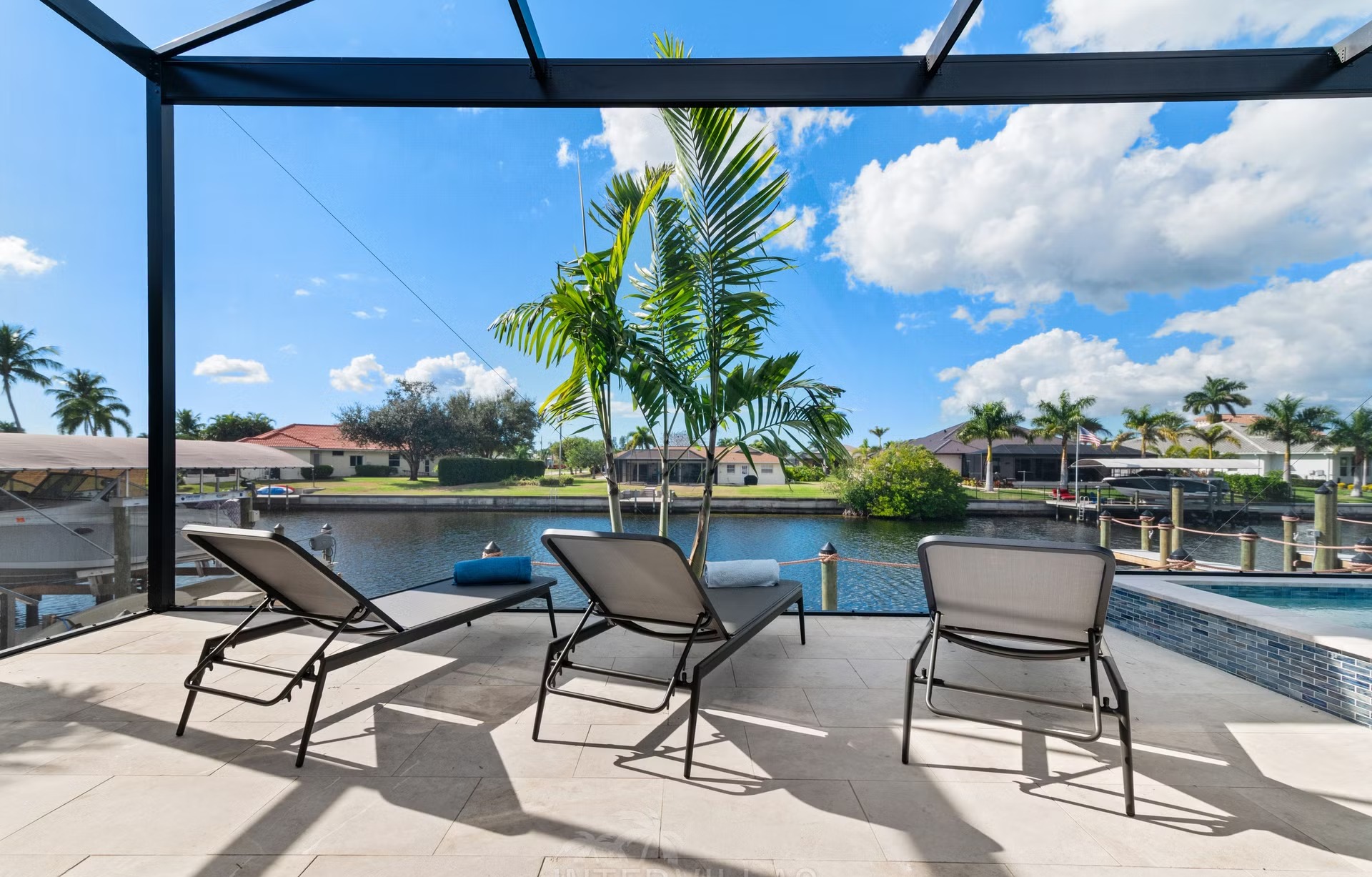 Moderne Villa am Kanal mit Salzwasserpool und Outdoor-Spa bei Sonnenuntergang.