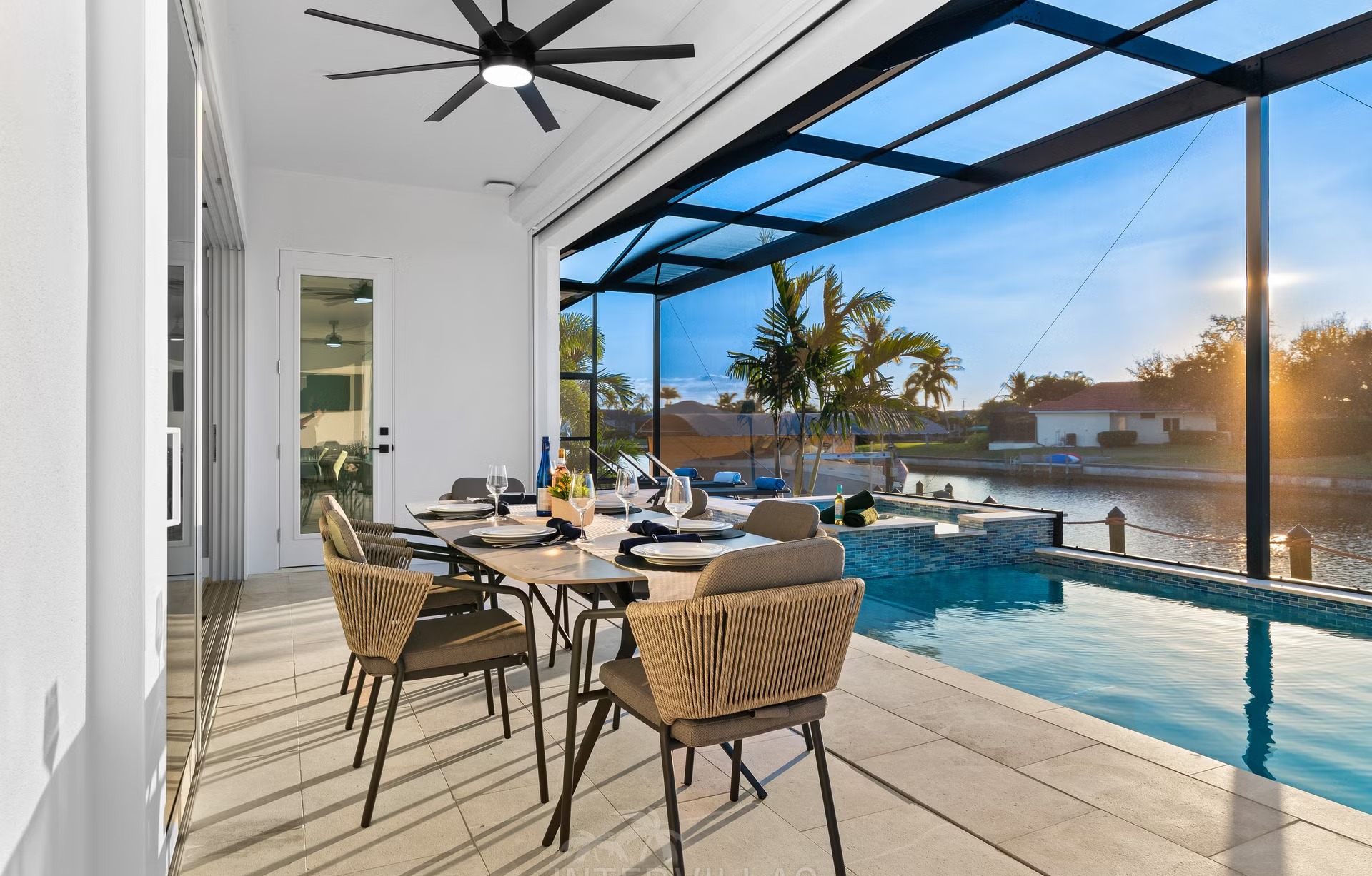 Moderne Villa am Kanal mit Salzwasserpool und Outdoor-Spa bei Sonnenuntergang.