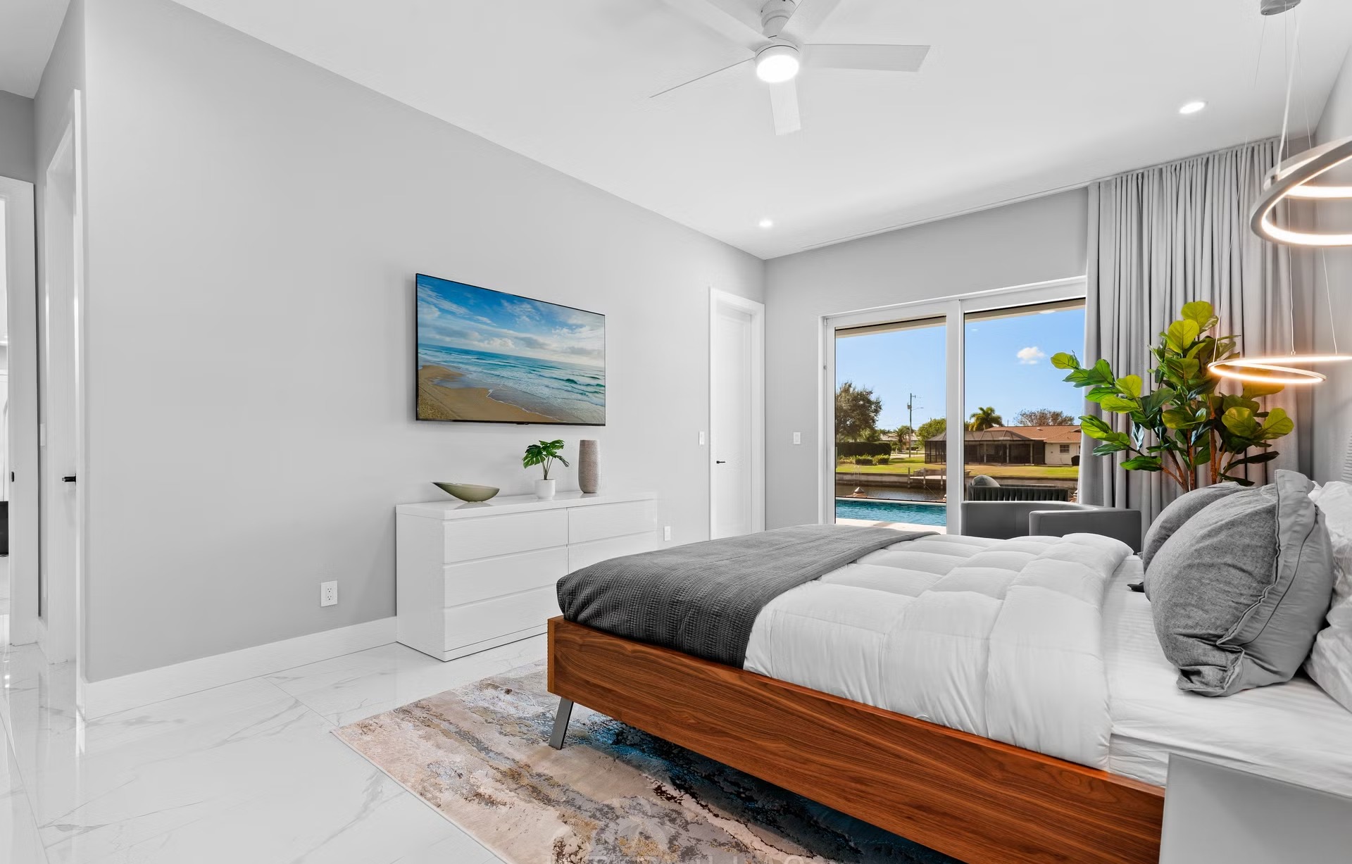 Moderne Villa am Kanal mit Salzwasserpool und Outdoor-Spa bei Sonnenuntergang.