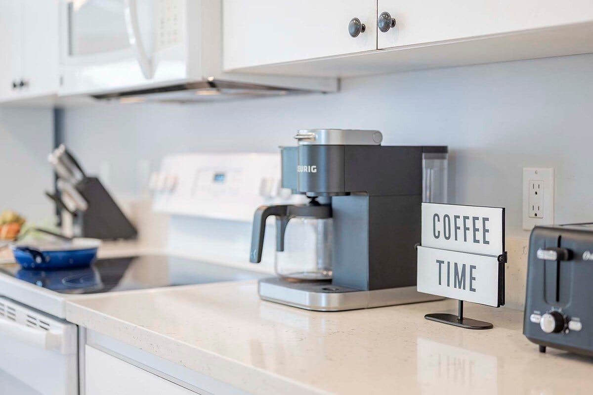 Überdachte Veranda mit Esstisch und Blick auf Pool und Kanal.