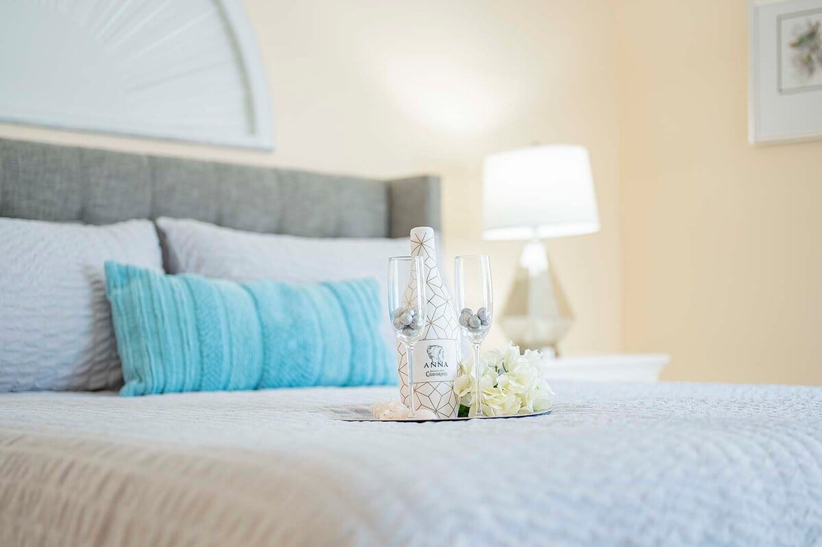 Überdachte Veranda mit Esstisch und Blick auf Pool und Kanal.