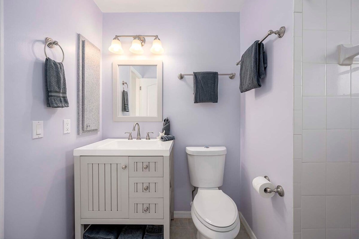 Überdachte Veranda mit Esstisch und Blick auf Pool und Kanal.