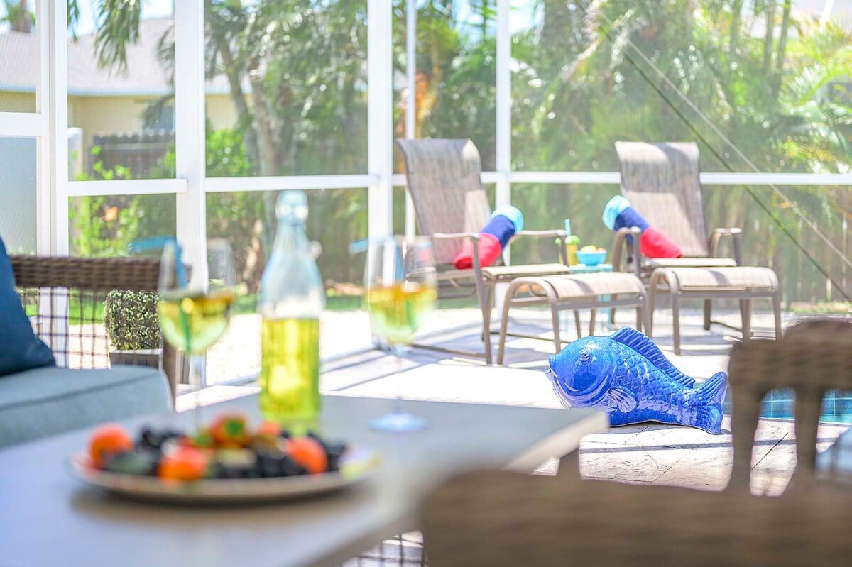 Überdachte Veranda mit Blick auf den Kanal und den Poolbereich.